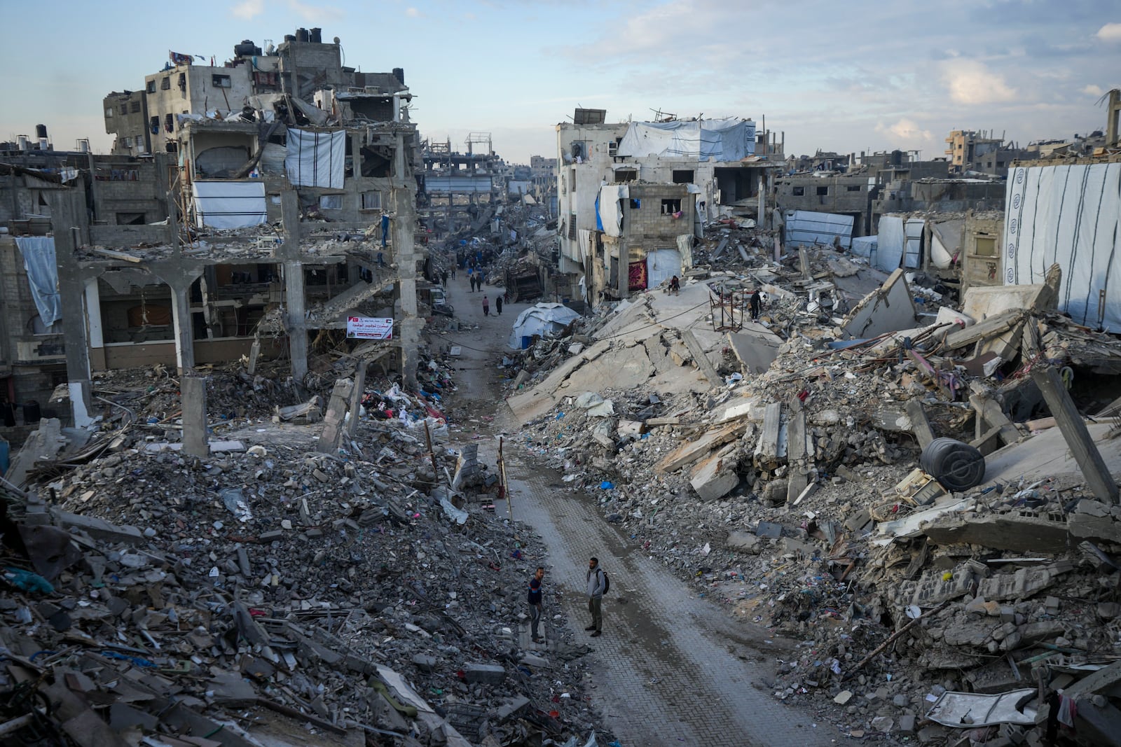 Palestinians walk in the destruction caused by the Israeli air and ground offensive in Jabaliya, Gaza Strip, Wednesday, Feb. 5, 2025. (AP Photo/Abdel Kareem Hana)