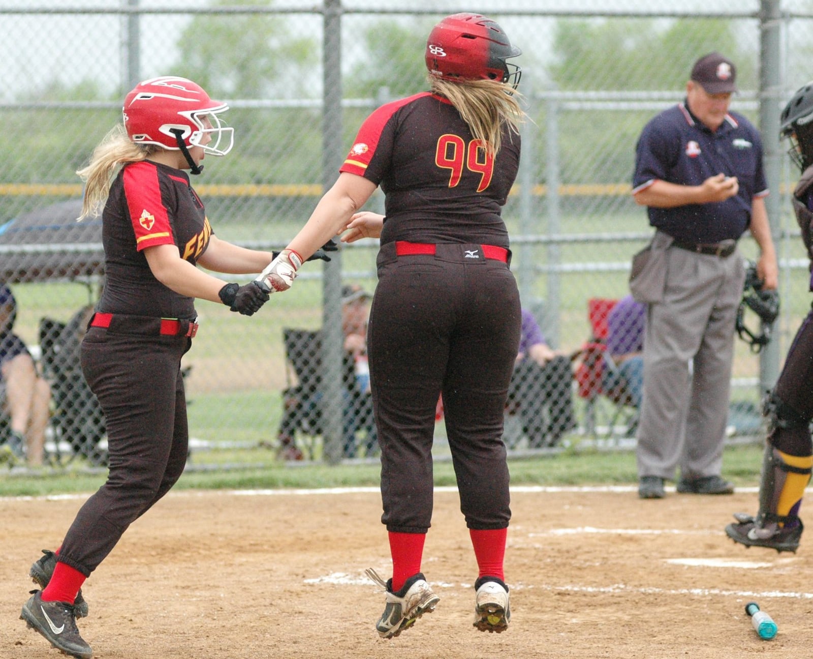 Fenwick’s Hannah Hemmingsen (left) and Leah Hemmingsen (99) react after they both scored a run Thursday during a 9-5 loss to visiting Bellbrook in a Division II sectional softball game in Middletown. RICK CASSANO/STAFF