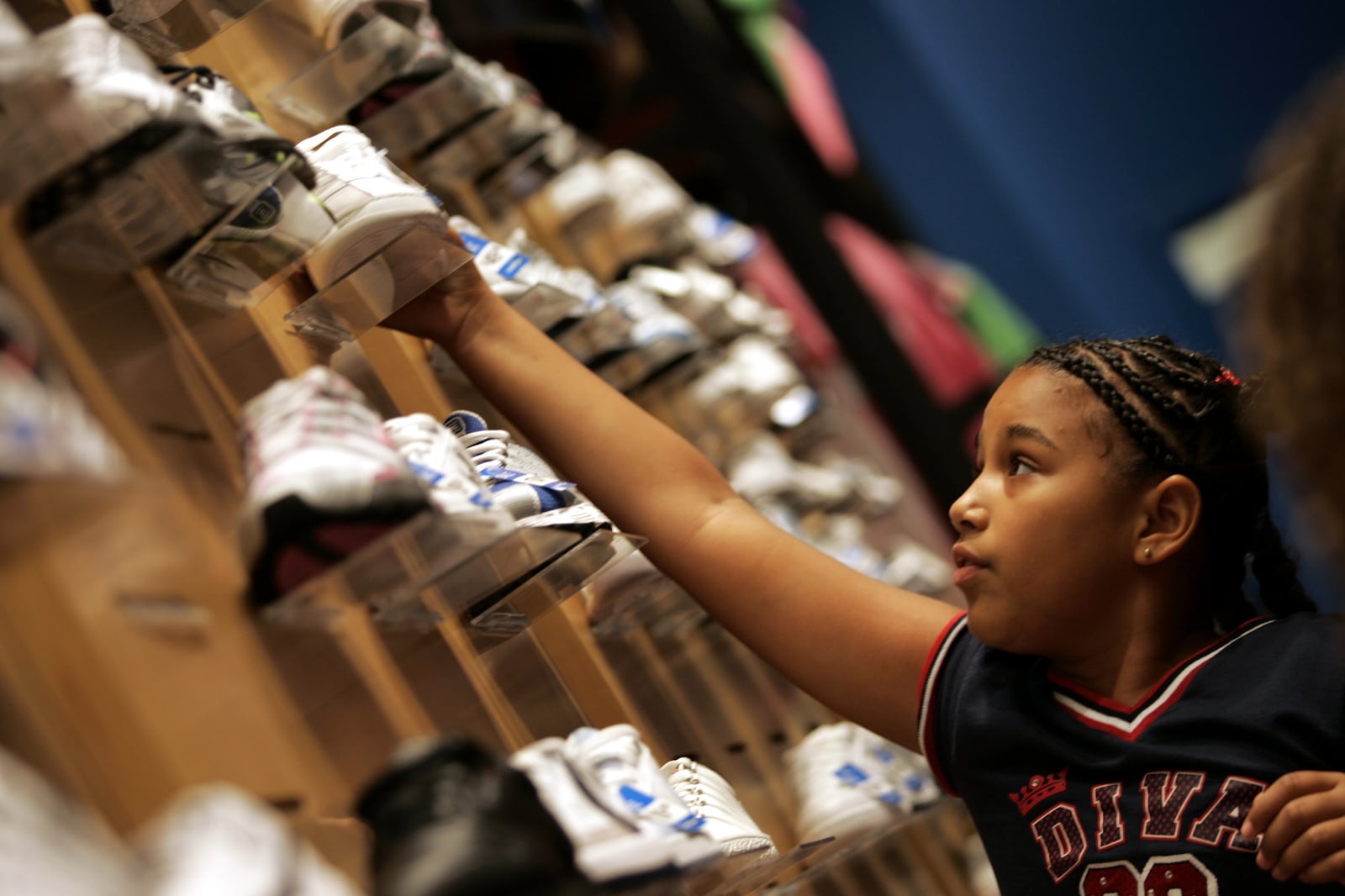 Shanice Thornton,10, checks another design as she searches for her back to school shoes at the Finish Line at Towne Mall in Middleotwn, Ohio Thursday Aug. 18, 2005.(AP Photo/Middletown Journal, Pat Auckerman)