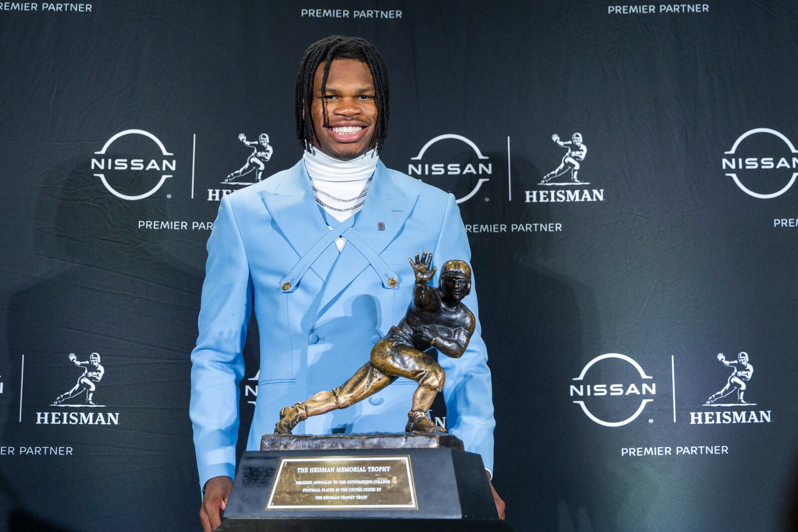 Heisman Trophy finalist Travis Hunter, of Colorado, stands with the trophy during a college football press conference, Saturday, Dec. 14, 2024, in New York. (AP Photo/Corey Sipkin)