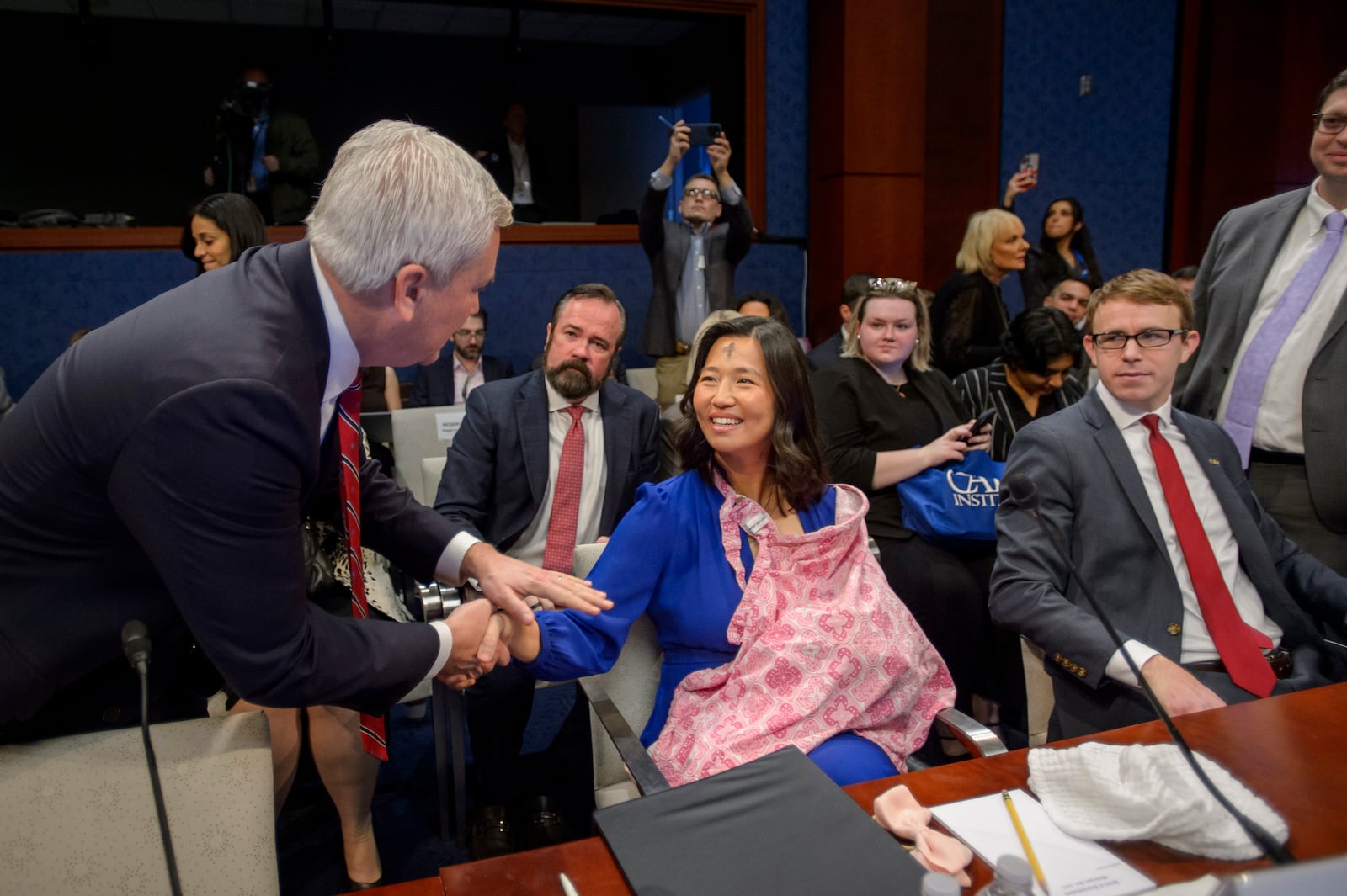 David J. Bier, right, Director of Immigration Studies at the Cato Institute lwatches as Boston Mayor Michelle Wu, center, nurses her daughter Mira while greeted by Chairman Rep. James Comer, R-Ky., left, before a House Committee on Oversight and Government Reform hearing with Sanctuary City Mayors on Capitol Hill, Wednesday, March 5, 2025, in Washington. (AP Photo/Rod Lamkey, Jr.)