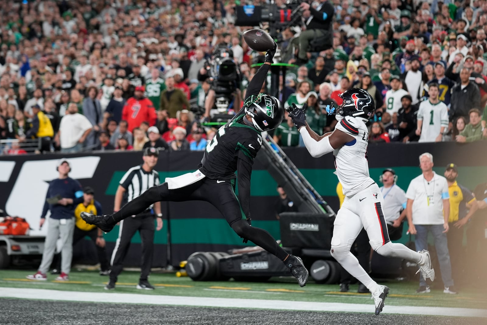 New York Jets wide receiver Garrett Wilson (5) catches a pass for a touchdown as Houston Texans cornerback Kamari Lassiter (4) defends during the second half of an NFL football game Thursday, Oct. 31, 2024, in East Rutherford, N.J. (AP Photo/Seth Wenig)