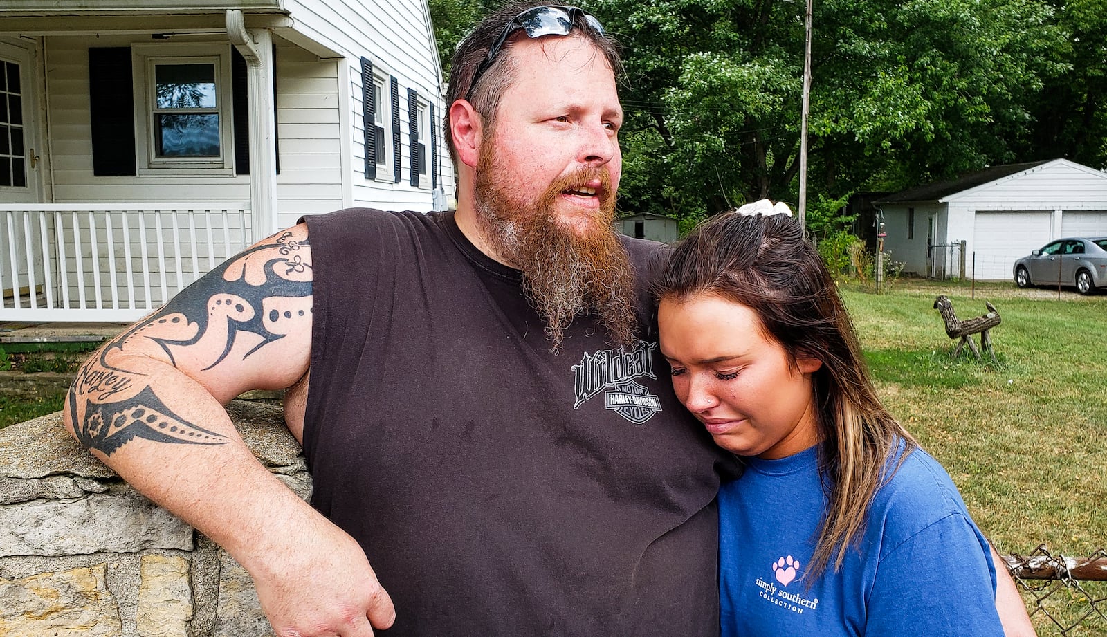 Kevin Foster, with his daughter Skylar Foster, talks to media after their German Shepherd named Ruger had to be put down from injuries sustained after a neighbor allegedly hit the dog with a baseball bat. Kevin Foster has the cage in his front yard with a sign saying "Be Their Voice" as a message to people driving by. A group of people gathered in front of the house to support the dog owners. NICK GRAHAM/STAFF