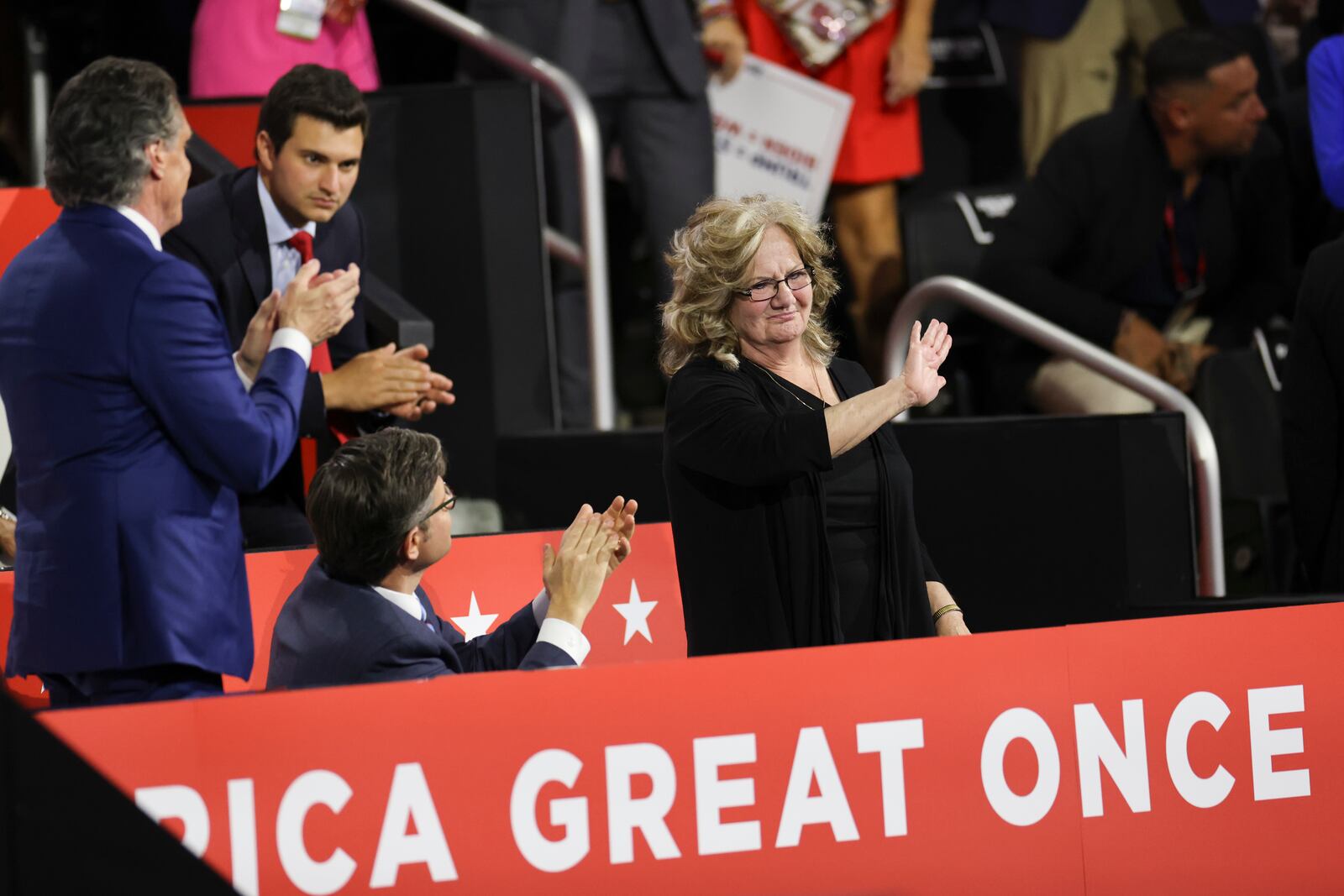 From left: Gov. Doug Burgum of North Dakota and House Speaker Mike Johnson (R-La.) applaud Beverly Vance, the mother of Sen. JD Vance (R-Ohio), the Republican vice presidential nominee, as he speaks on the third night of the Republican National Convention at the Fiserv Forum in Milwaukee, on Wednesday, July 17, 2024. (Maddie McGarvey/The New York Times)
                      