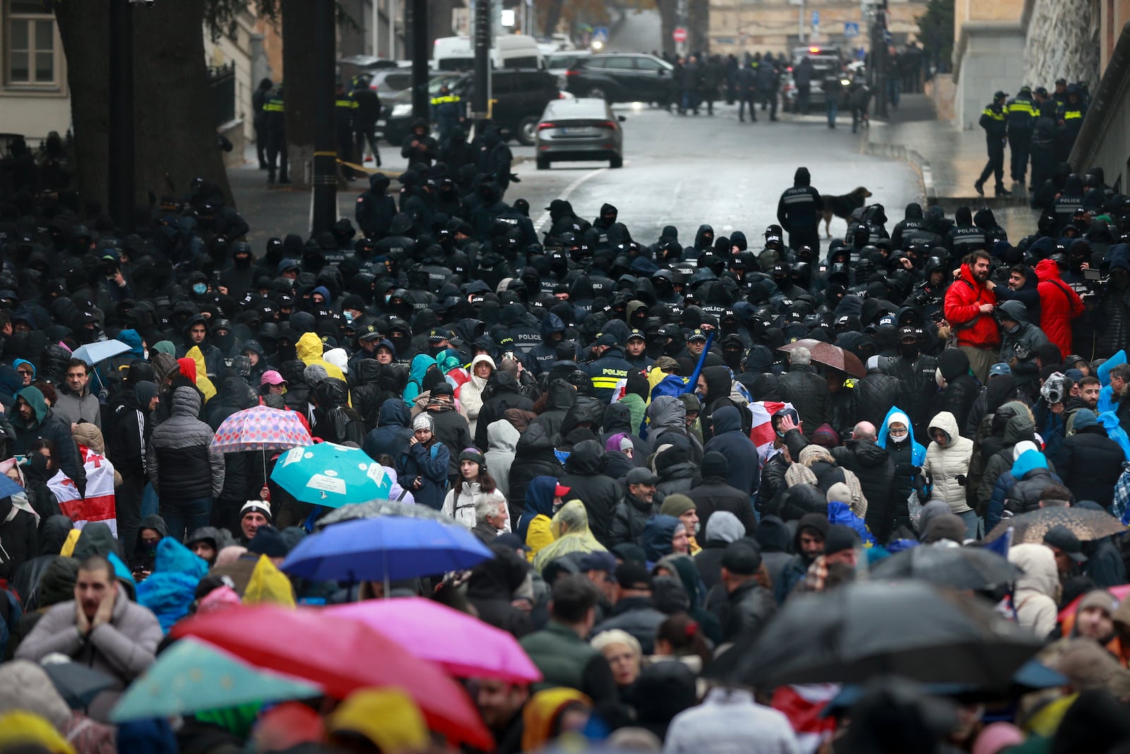 Police block protesters gathered in a street during a rally to demand new parliamentary elections in the country, near the Parliament's building in Tbilisi, Georgia, Monday, Nov. 25, 2024. (AP Photo/Zurab Tsertsvadze)