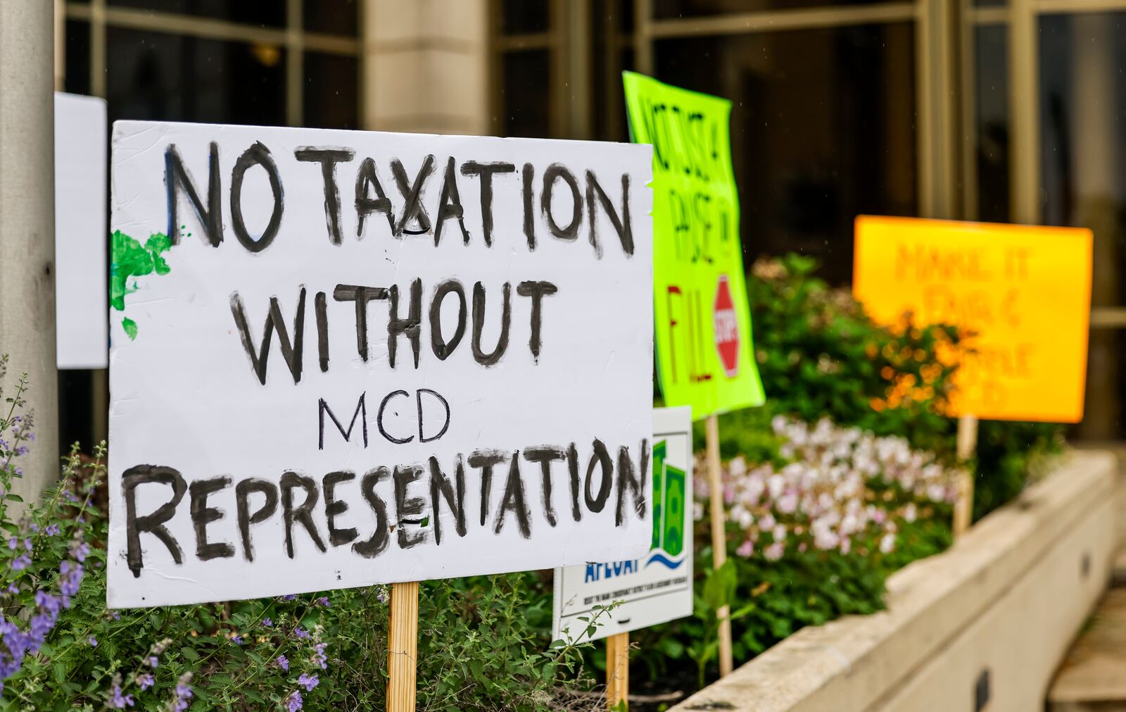 A group of concerned citizens protests before a Miami Conservancy District meeting to discuss the recent assessment increase Friday, May 3, 2024 in Hamilton. The Miami Conservancy District board adopted a resolution to rescind the revised appraisal record of benefits previously filed in March. NICK GRAHAM/STAFF