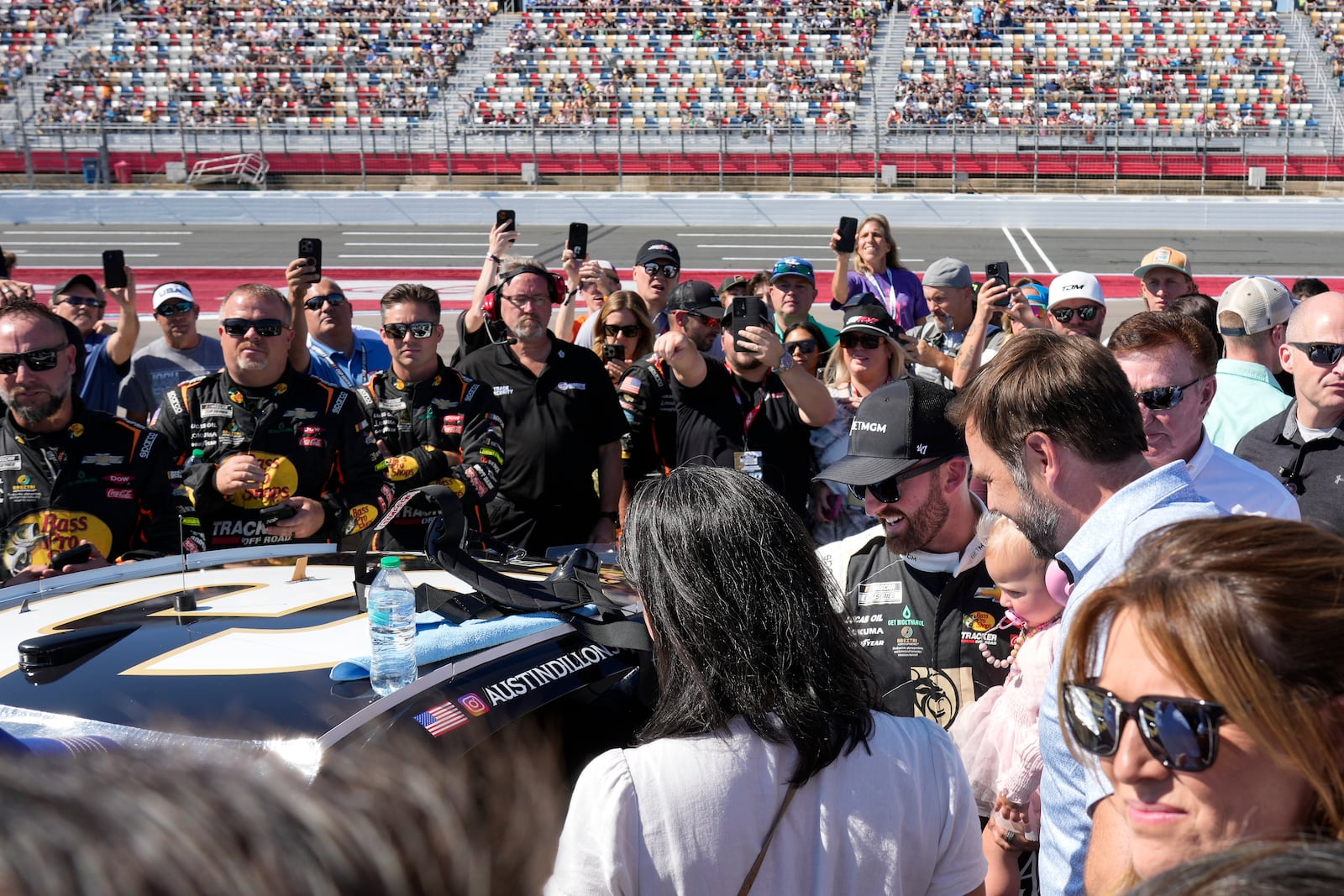 Republican vice presidential nominee Sen. JD Vance, R-Ohio, right, talks with driver Austin Dillon, second from right, at Dillon's race car during a campaign visit to Charlotte Motor Speedway in Concord, N.C., Sunday, Oct. 13, 2024. (AP Photo/Chuck Burton)