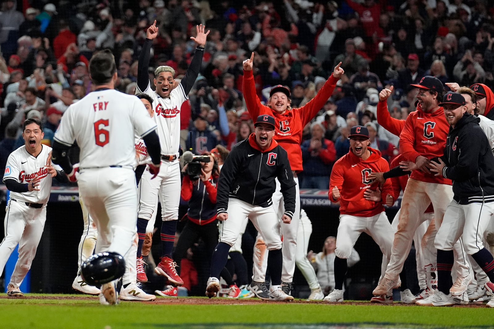 Cleveland Guardians players wait for David Fry (6) to cross home plate after hitting a game-winning two-run home run against the New York Yankees during the 10th inning in Game 3 of the baseball AL Championship Series Thursday, Oct. 17, 2024, in Cleveland. The Guardians won 7-5. (AP Photo/Jeff Roberson)