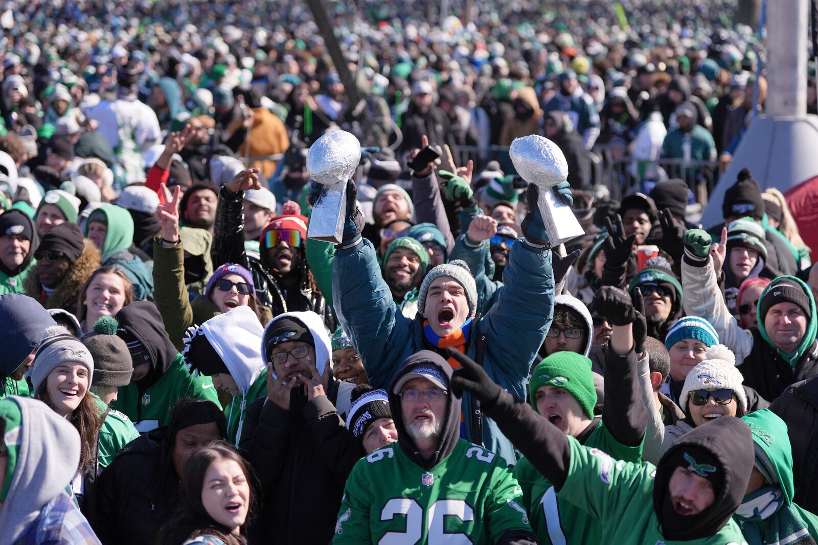 A fan holds up mock Vince Lombardi trophies and cheers during the Philadelphia Eagles NFL football Super Bowl 59 parade and celebration, Friday, Feb. 14, 2025, in Philadelphia. (AP Photo/Matt Rourke)