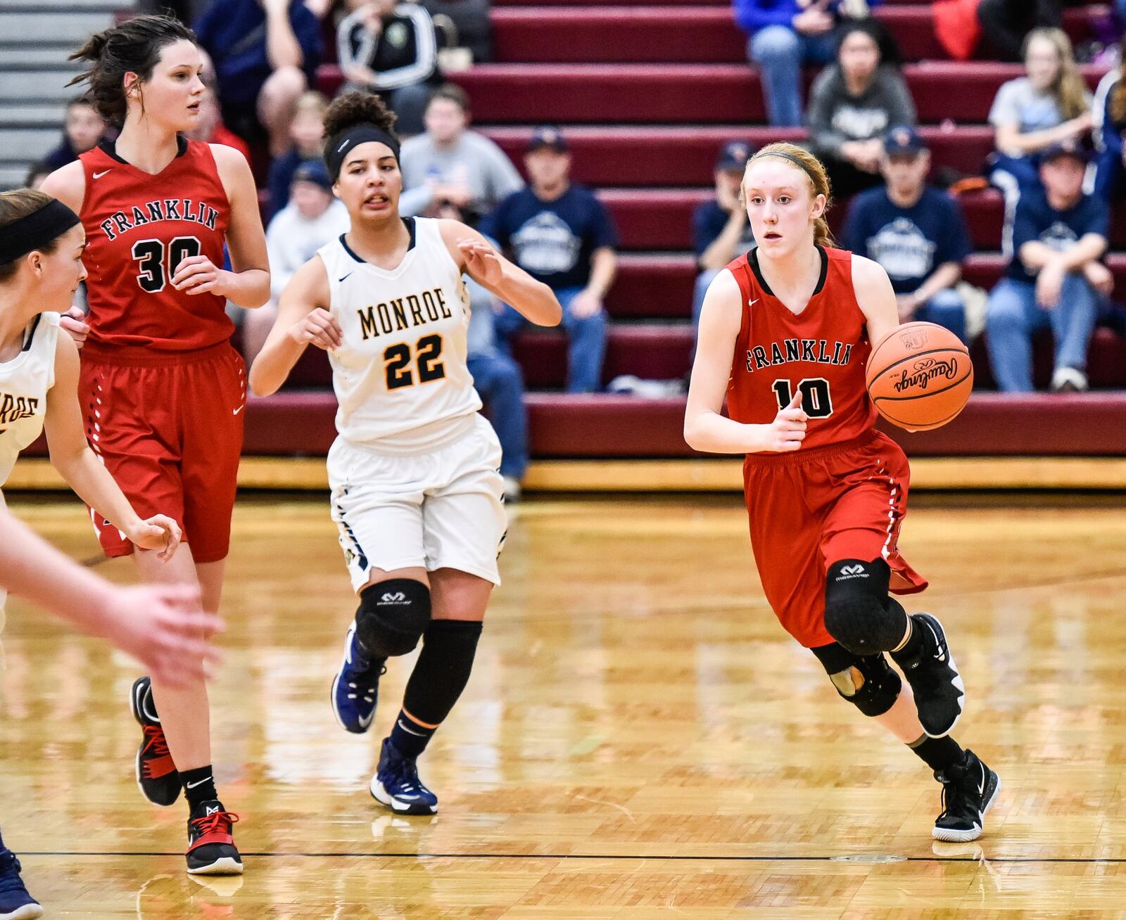 Franklin’s Jordan Rogers dribbles up the court as teammate Layne Ferrell (30) and Monroe’s Jahsalyn Robinson (22) trail her during a Division II sectional final Feb. 26 at Lebanon. NICK GRAHAM/STAFF