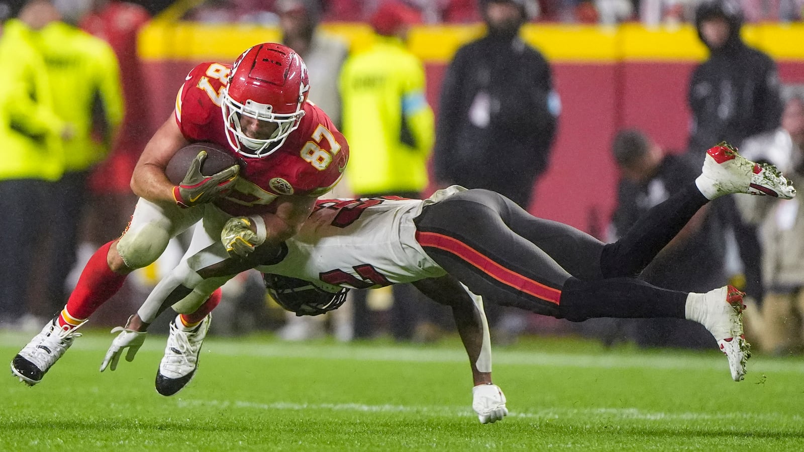 Tampa Bay Buccaneers safety Josh Hayes (32) hits Kansas City Chiefs tight end Travis Kelce (87) during the second half of an NFL football game, Monday, Nov. 4, 2024, in Kansas City, Mo. (AP Photo/Charlie Riedel)