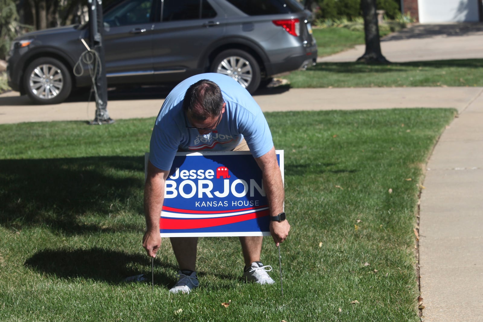 Kansas state Rep. Jesse Borjon, R-Topeka, puts a campaign sign in the yard of a supporter, Saturday, Oct. 5, 2024, in Topeka, Kansas. (AP Photo/John Hanna)