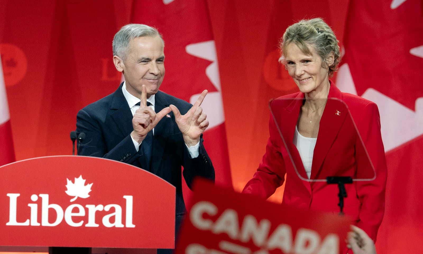 Newly appointed Liberal Leader Mark Carney and his wife Diana Fox Carney stand onstage following his speech at the Liberal leadership announcement in Ottawa, Ontario, Sunday, March 9, 2025. (Adrian Wyld/The Canadian Press via AP)