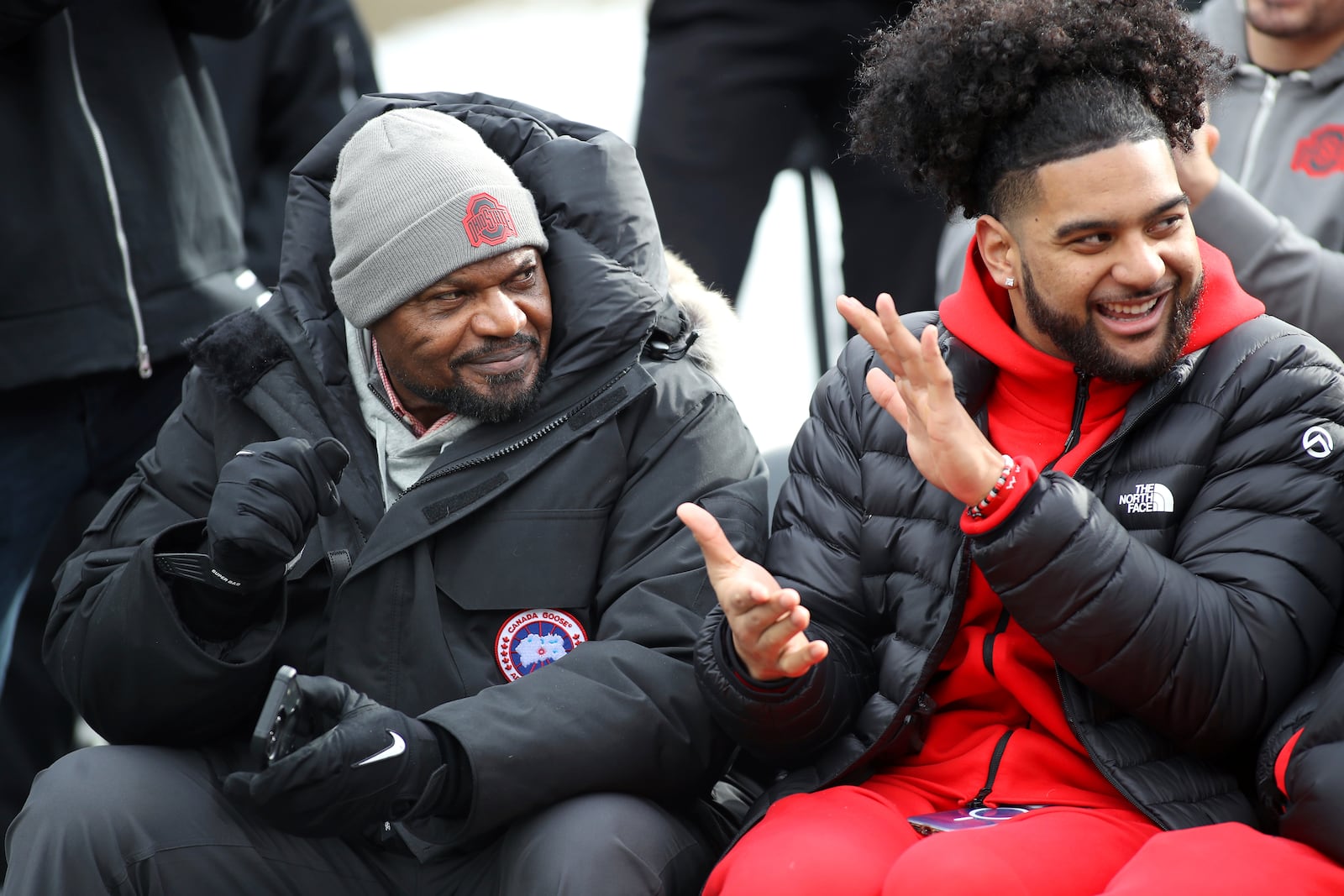 Ohio State Buckeyes defensive line coach Larry Johnson (left) and Ohio State Buckeyes defensive end JT Tuimoloau, react to the speeches given during the National Championship celebration at Ohio Stadium in Columbus, Ohio, Sunday, Jan. 26, 2025. (AP Photo/Joe Maiorana)