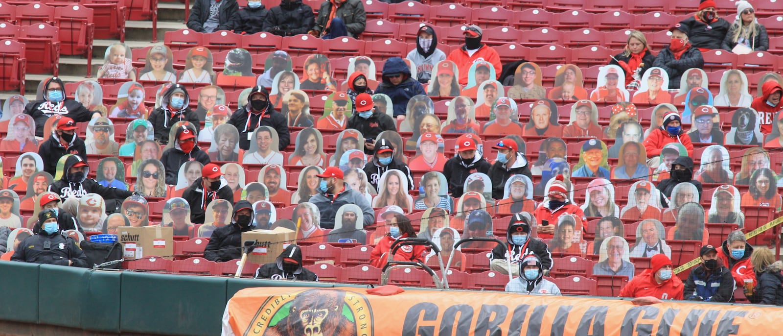 Members of the Reds ground crew sit among fan cutouts on Opening Day on Thursday, April 1, 2021, at Great American Ball Park in Cincinnati. David Jablonski/Staff