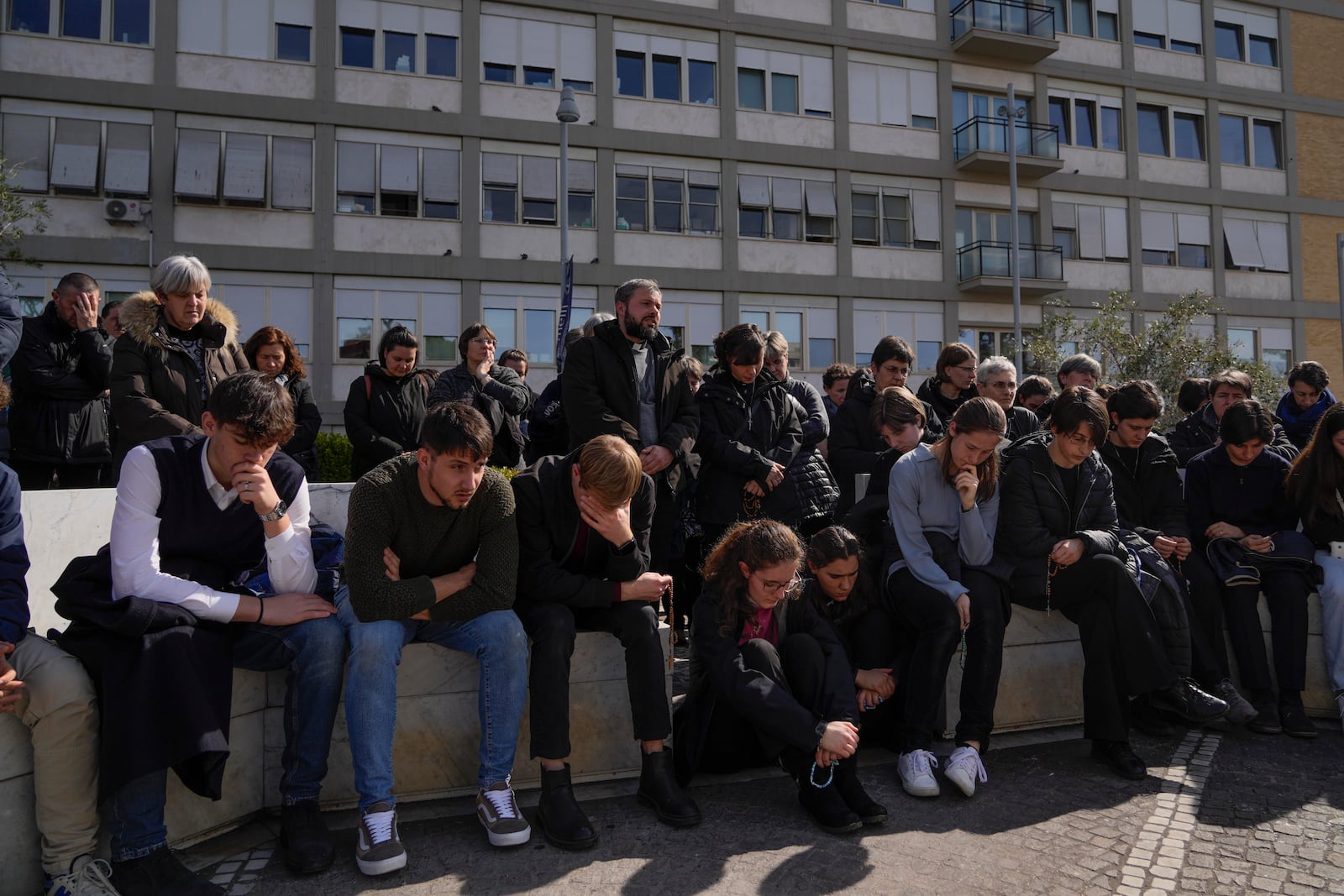 People pray outside the Agostino Gemelli Polyclinic in Rome, Sunday, Feb. 23, 2025, where Pope Francis is hospitalized since Feb. 14. (AP Photo/Gregorio Borgia)