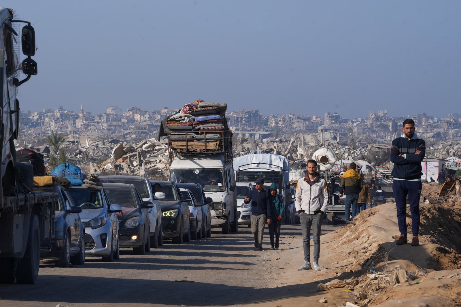 Displaced Palestinians, traveling in vehicles, wait to cross through a security checkpoint at the Netzarim corridor as they make their way from central Gaza to the northern Gaza Strip, Tuesday, Feb. 18, 2025. (AP Photo/Abdel Kareem Hana)