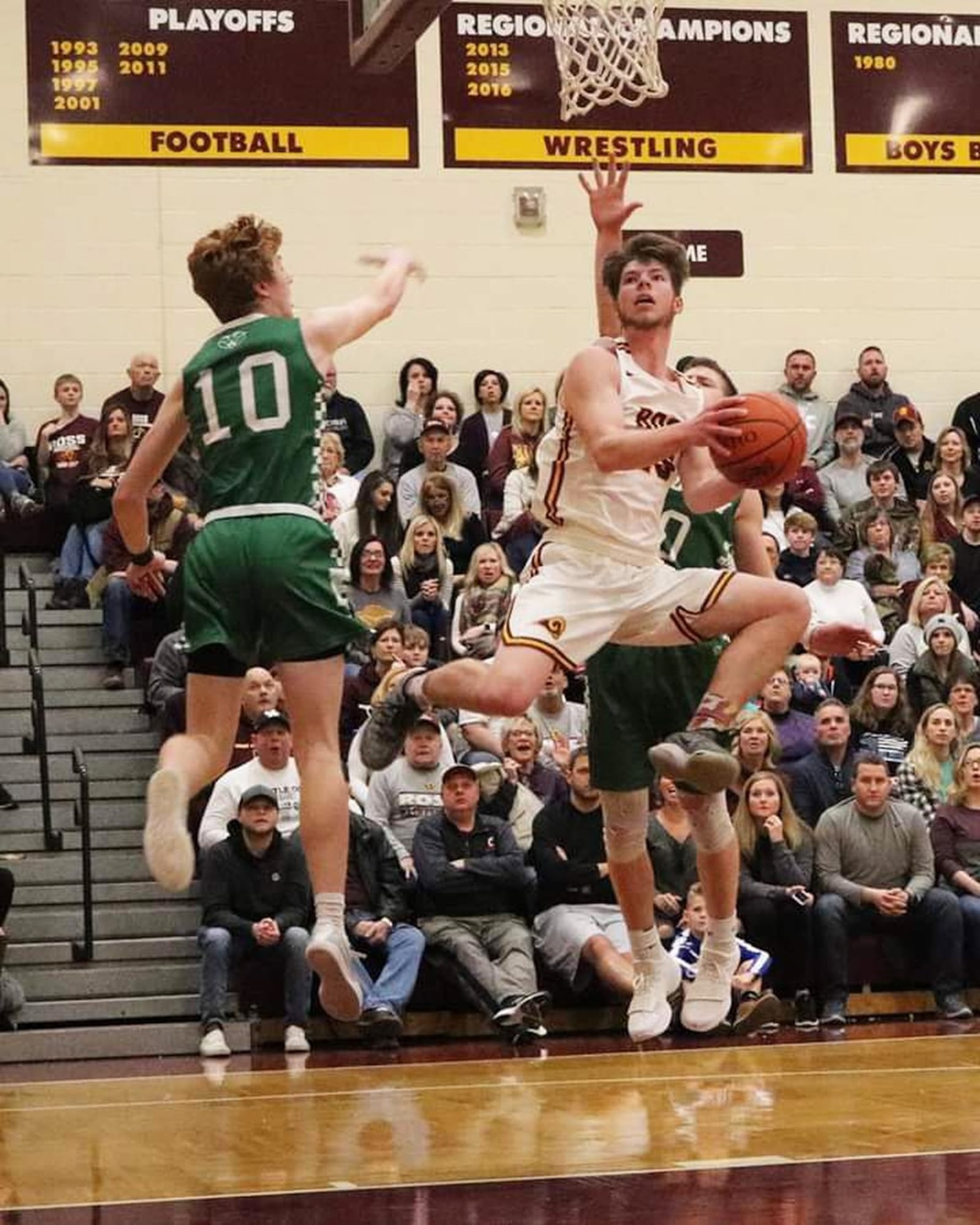 Cole Gronas of Ross (25) flies between Zach Switzer (10) and Alex DeLong (20) of Badin during Saturday night’s game in Ross Township. Badin won 51-38. CONTRIBUTED PHOTO BY TERRI ADAMS