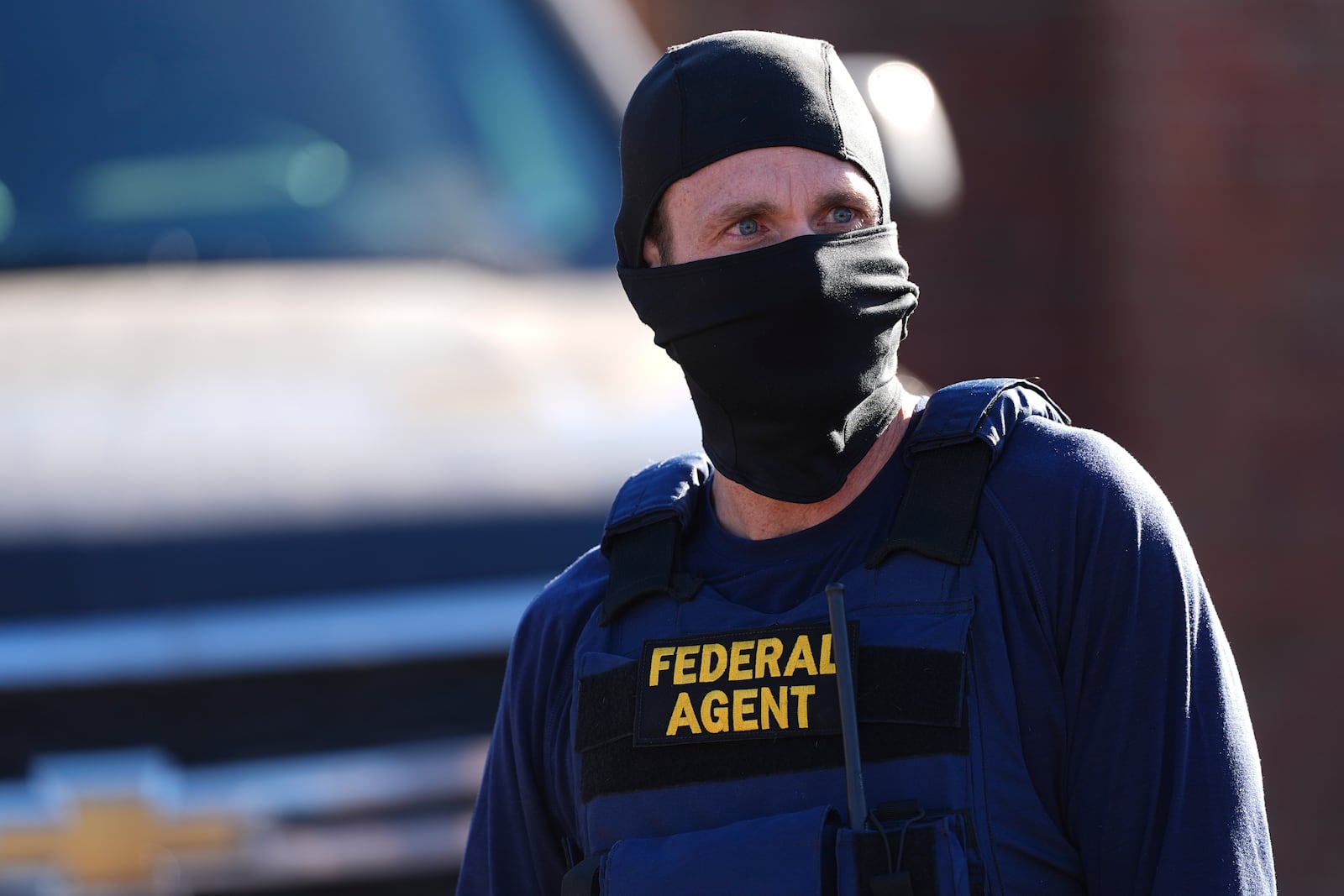 A federal agent stands watch outside an apartment complex during a raid Wednesday, Feb. 5, 2025, in east Denver. (AP Photo/David Zalubowski)