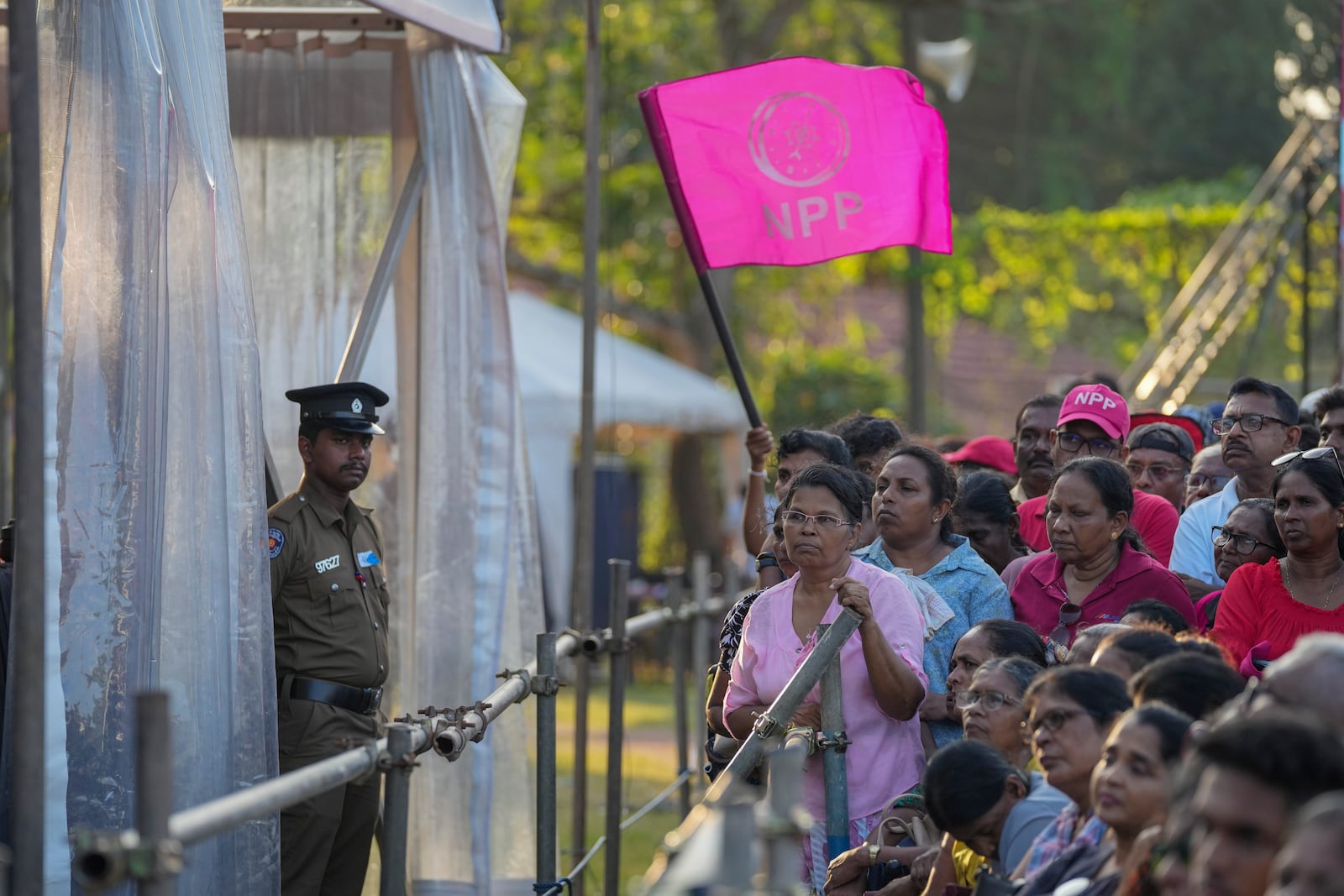 A woman holds a flag of Sri Lankan President Anura Kumara Dissanayake 's National People's Power party during a public rally ahead of Thursday's parliamentary election in Gampaha, Sri Lanka, Monday, Nov. 11, 2024. (AP Photo/Eranga Jayawardena)