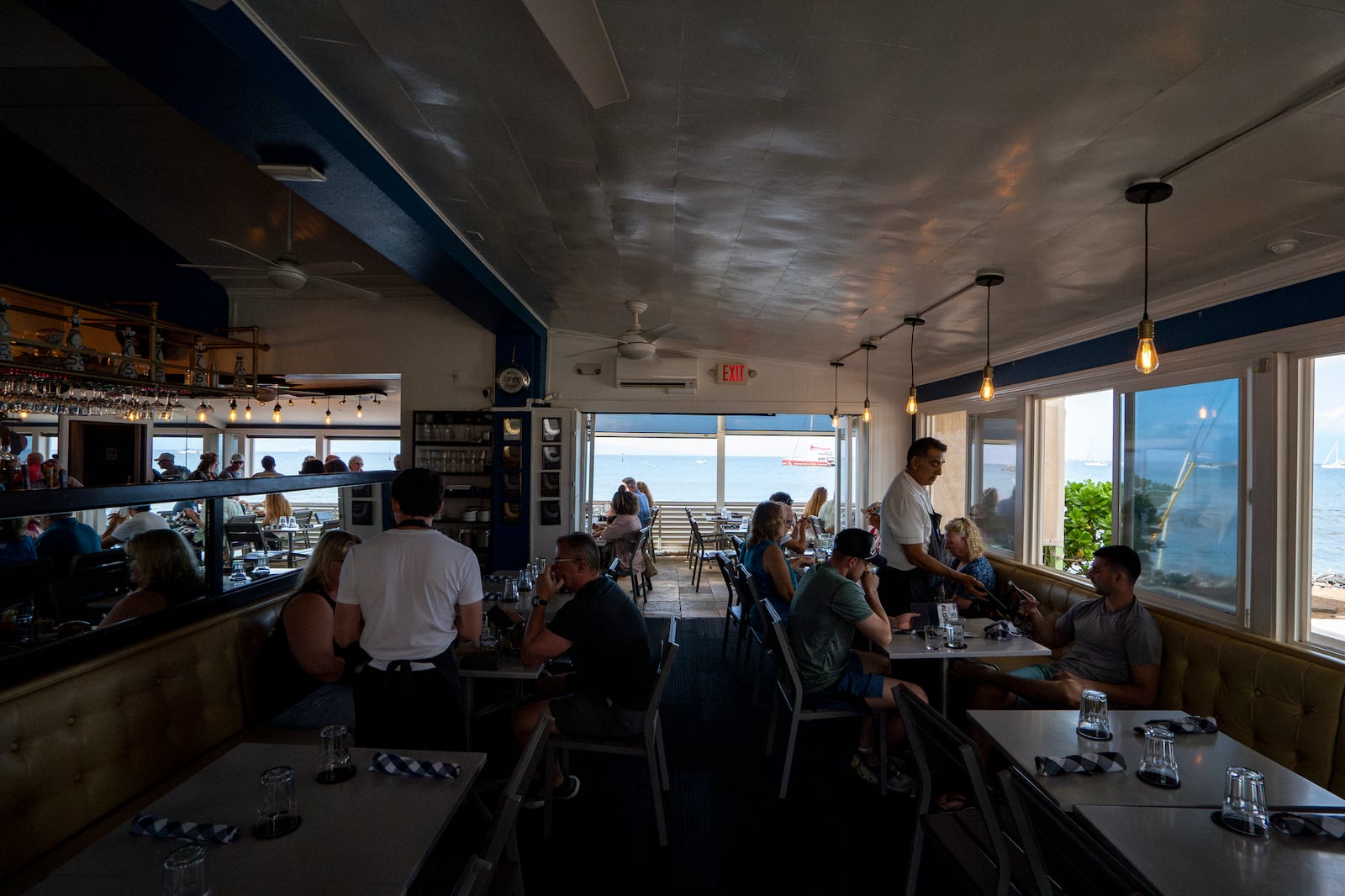 Guests enjoy their lunch at Mala Ocean Tavern, Monday, Nov. 18, 2024, in Lahaina, Hawaii. Mala Ocean Tavern is the first restaurant on Front Street to reopen after last year's wildfire. (AP Photo/Mengshin Lin)