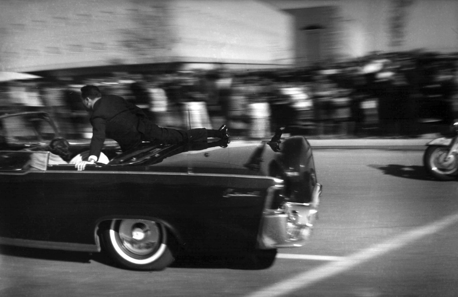 FILE - In this Nov. 22, 1963 file photo, the limousine carrying mortally wounded President John F. Kennedy races toward the hospital seconds after he was shot in Dallas. (AP Photo/Justin Newman, File)