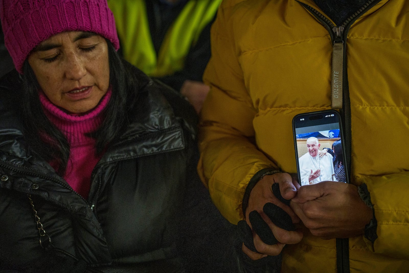 Faithful hold a smartphone with a picture of Pope Francis as they pray during a nightly rosary for his recovery in St. Peter's Square at The Vatican, Monday, Feb. 24, 2025. (AP Photo/Bernat Armangue)