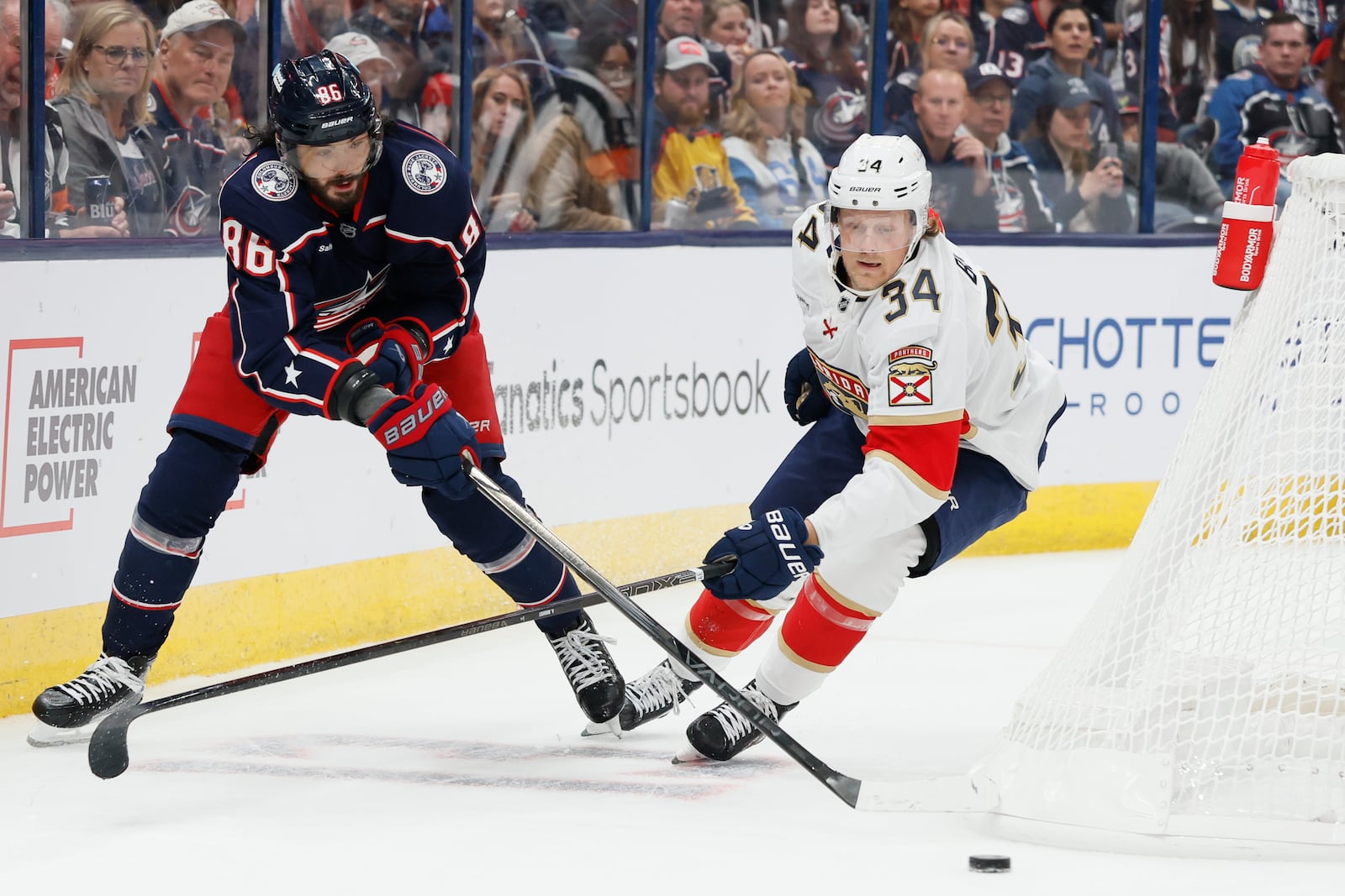 Columbus Blue Jackets' Kirill Marchenko, left, passes the puck past Florida Panthers' Adam Boqvist during the second period of an NHL hockey game Tuesday, Oct. 15, 2024, in Columbus, Ohio. (AP Photo/Jay LaPrete)