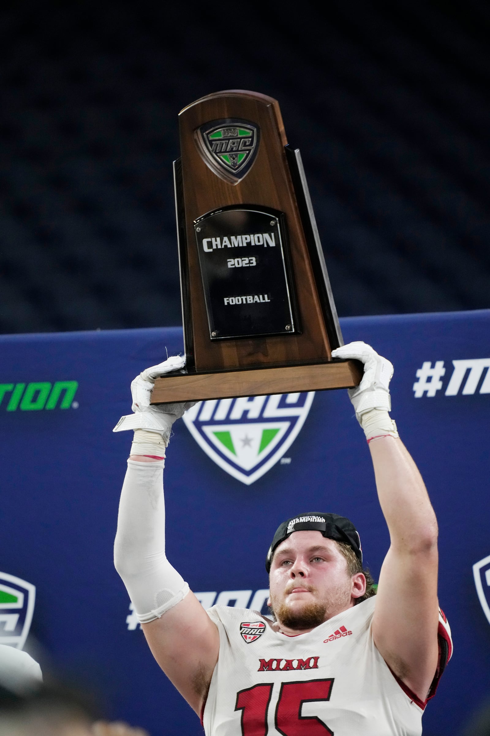 Miami (Ohio) linebacker Matt Salopek holds the Mid-American Conference championship NCAA college football game trophy, Saturday, Dec. 2, 2023, in Detroit. Miami (Ohio) defeated Toledo 23-14. (AP Photo/Carlos Osorio)