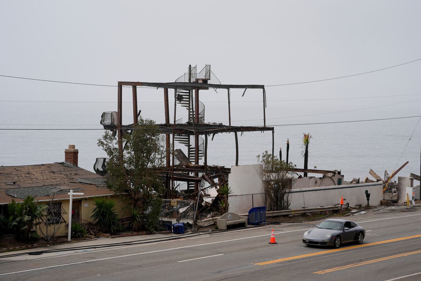 Motorists make their way along Pacific Coast Highway past beachfront homes destroyed by the Palisades Fire Monday, Feb. 3, 2025, in Malibu, Calif. (AP Photo/Damian Dovarganes)