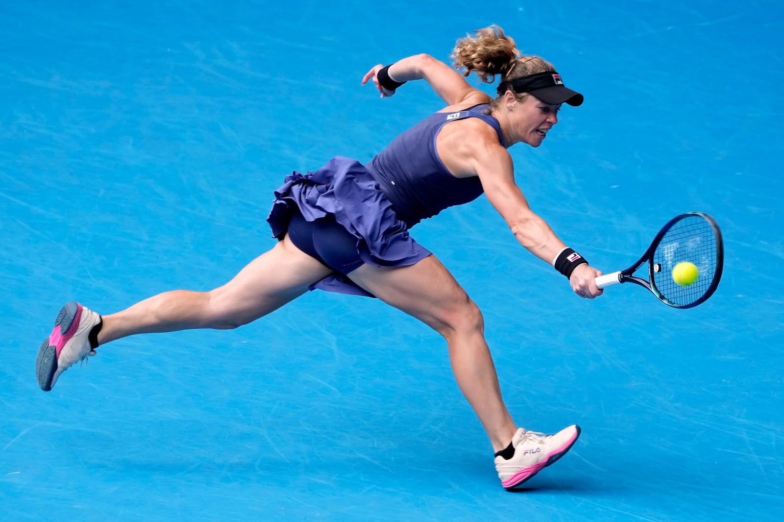 Laura Siegemund of Germany plays a backhand return to Zheng Qinwen of China during their second round match at the Australian Open tennis championship in Melbourne, Australia, Wednesday, Jan. 15, 2025. (AP Photo/Asanka Brendon Ratnayake)