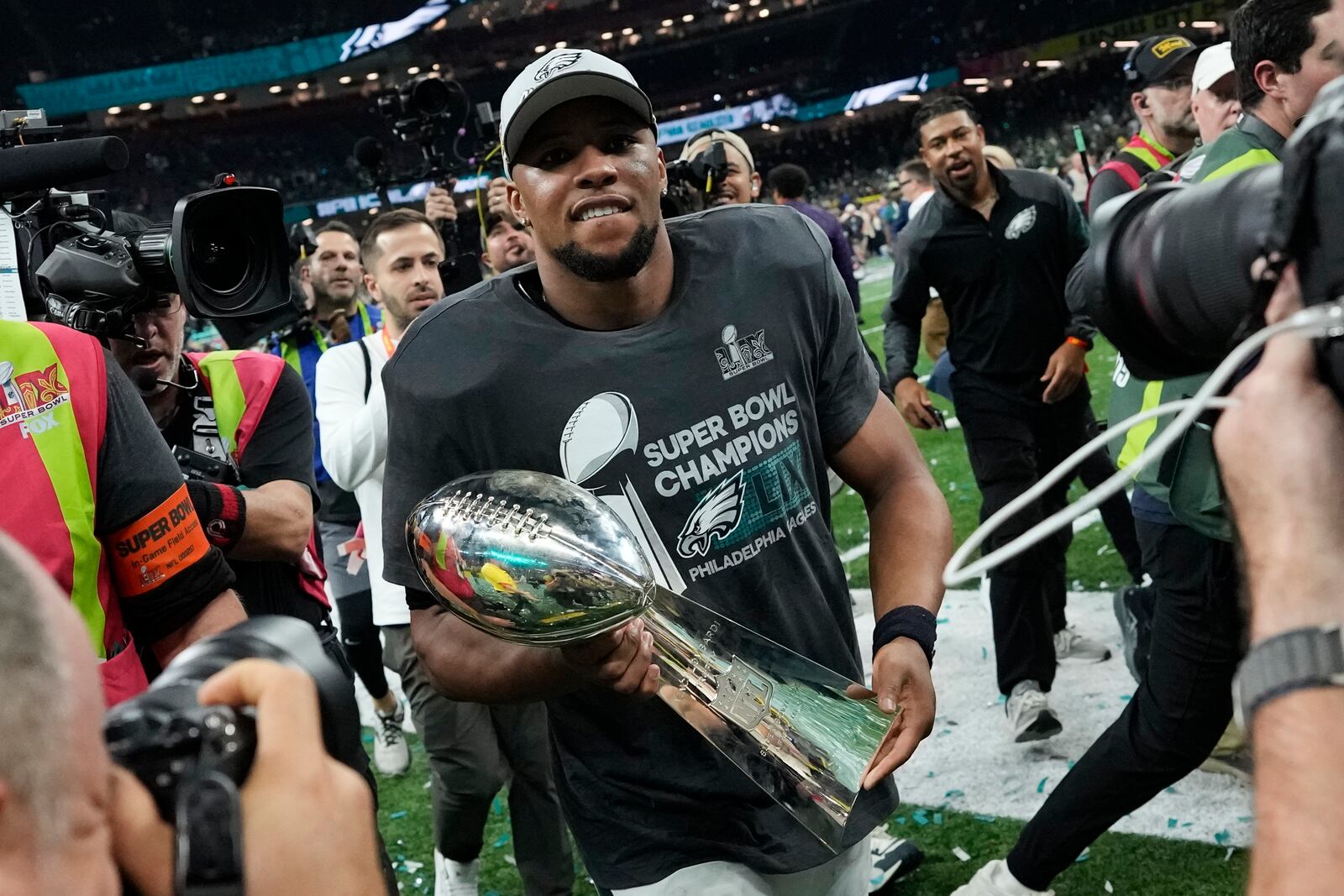 Philadelphia Eagles running back Saquon Barkley carries the Vince Lombardi Trophy after the NFL Super Bowl 59 football game against the Kansas City Chiefs, Sunday, Feb. 9, 2025, in New Orleans. (AP Photo/Ashley Landis)