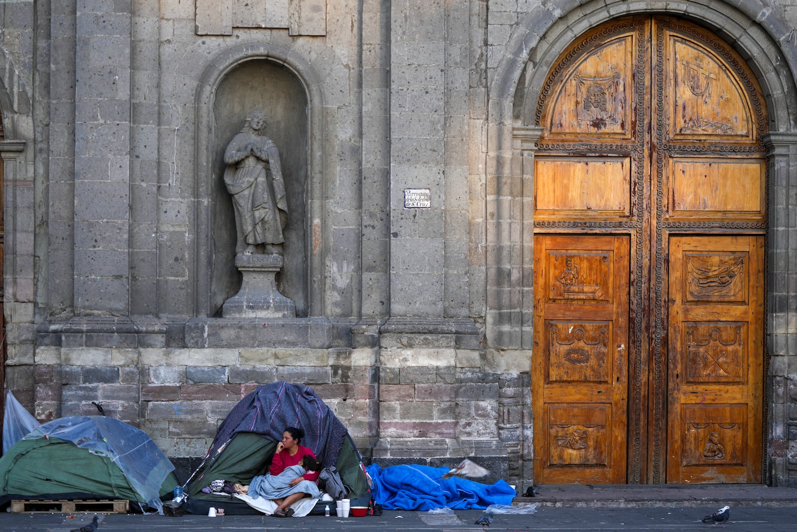 A Venezuelan migrant wakes up at a migrant tent camp outside La Soledad church in Mexico City, Monday, Jan. 20, 2025, the inauguration day of U.S. President Donald Trump. (AP Photo/Fernando Llano)