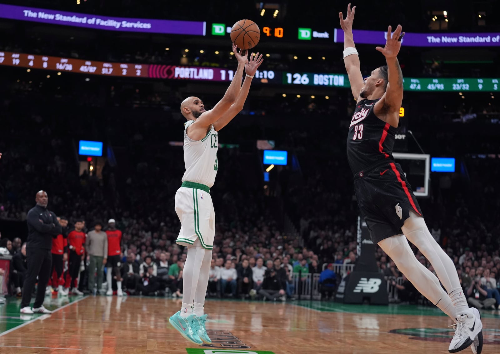 Boston Celtics guard Derrick White, left, takes a shot over Portland Trail Blazers forward Toumani Camara (33) during the second half of an NBA basketball game, Wednesday, March 5, 2025, in Boston. (AP Photo/Charles Krupa)