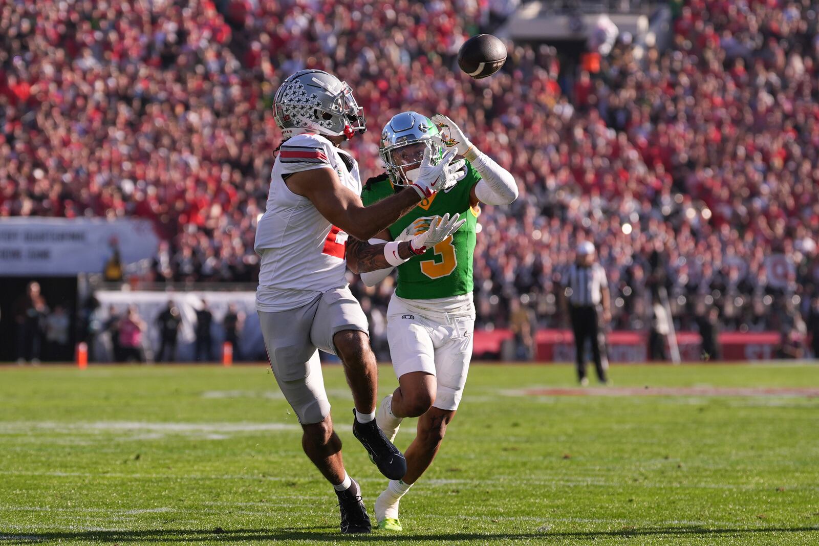 Ohio State wide receiver Emeka Egbuka (2) catches a touchdown pass as Oregon defensive back Brandon Johnson (3) defends during the first half in the quarterfinals of the Rose Bowl College Football Playoff, Wednesday, Jan. 1, 2025, in Pasadena, Calif. (AP Photo/Mark J. Terrill)