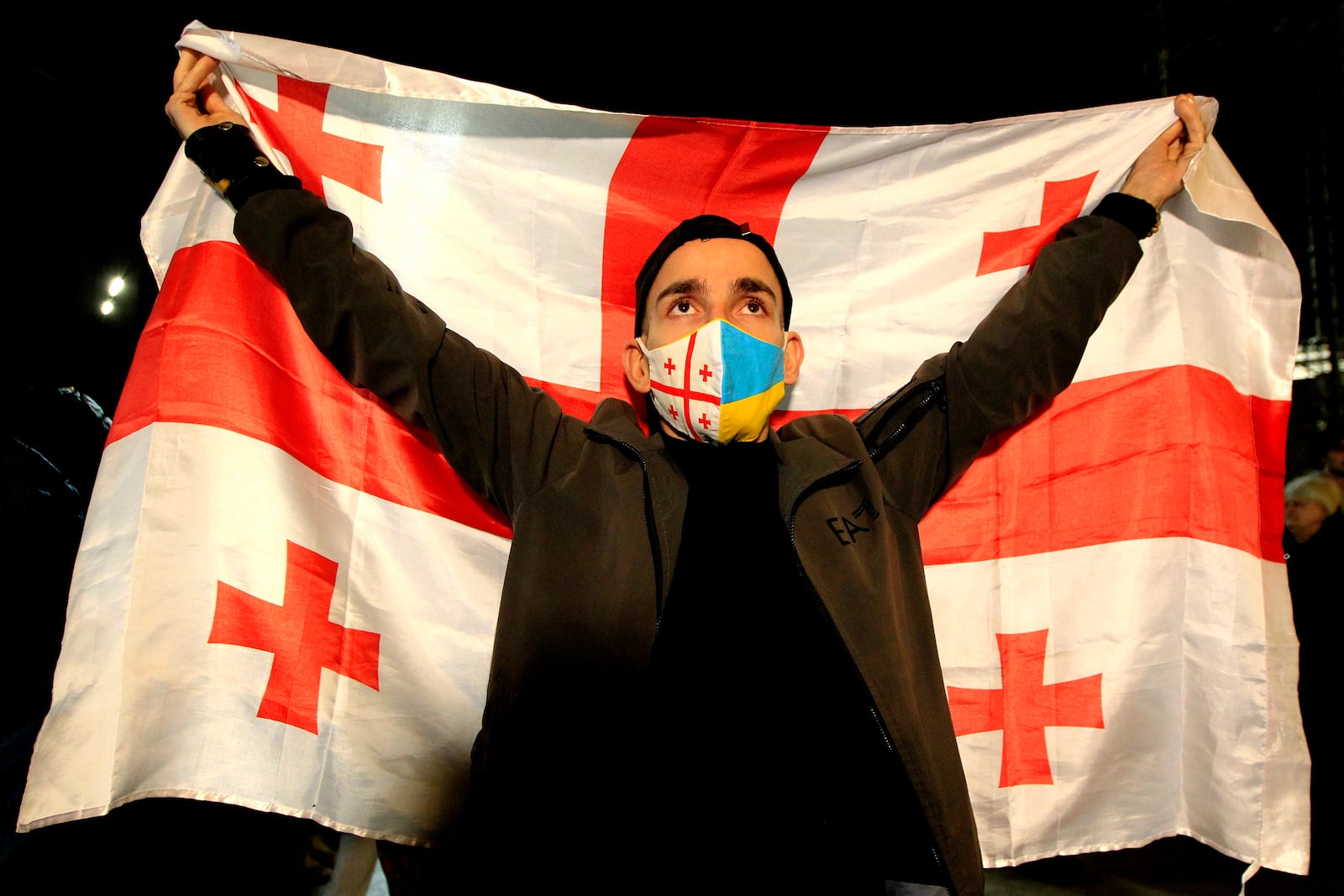 A man holds a Georgian flag during an opposition protest against the results of the parliamentary election in Tbilisi, Georgia, Monday, Oct. 28, 2024. (AP Photo/Shakh Aivazov)