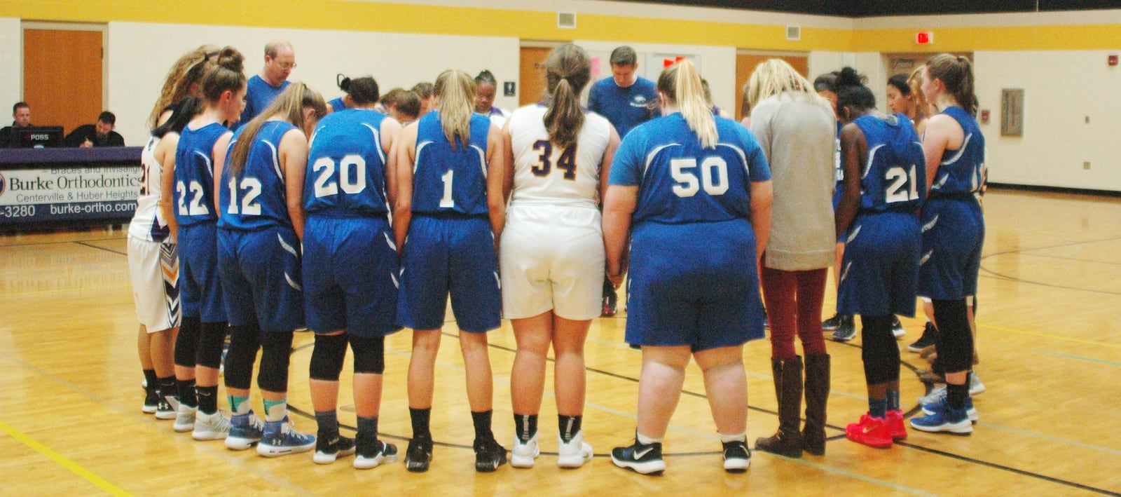 Middletown Christian (in blue) and Dayton Christian players and coaches get together for a postgame prayer Thursday night at Watts Middle School in Centerville. Dayton Christian won 48-35. RICK CASSANO/STAFF