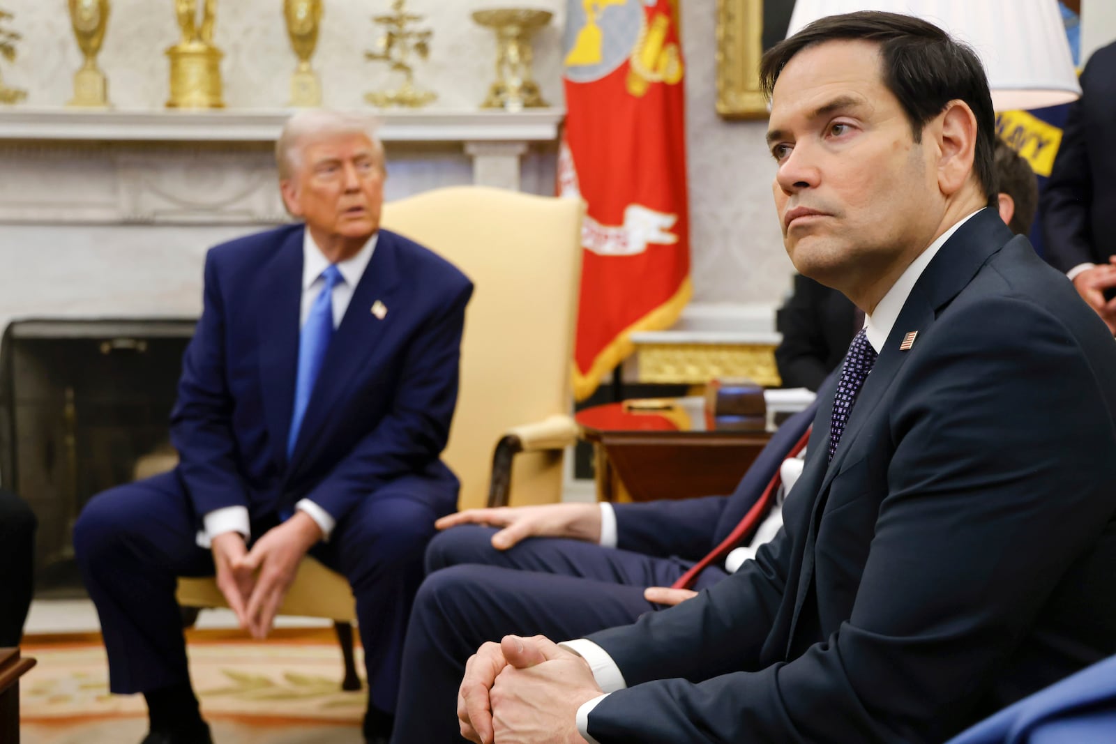 Secretary of State Marco Rubio, right, listens as President Donald Trump, left, meets with France's President Emmanuel Macron in the Oval Office of the White House in Washington, Monday, Feb. 24, 2025. (Ludovic Marin/Pool via AP)