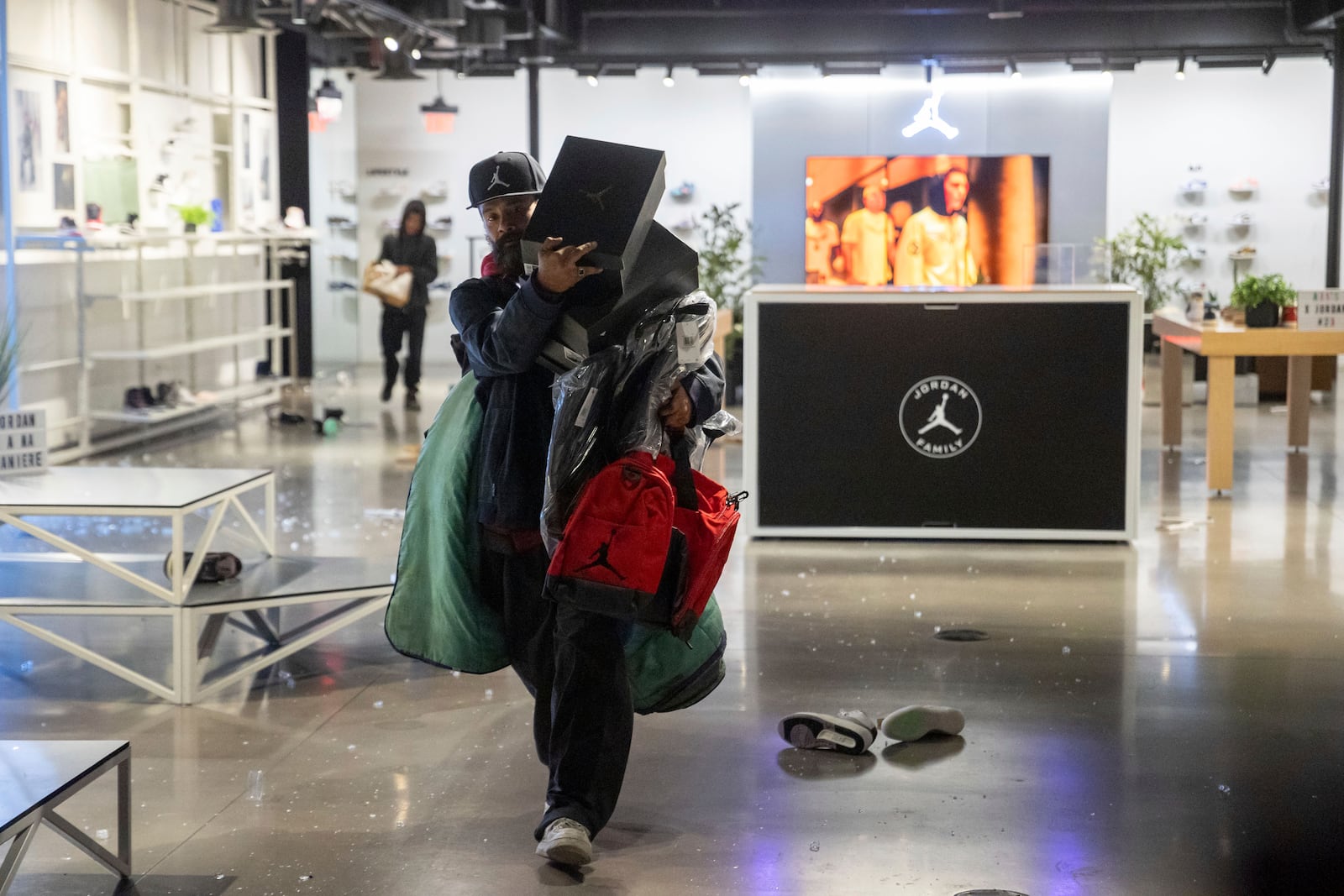 People carries out items from a ransacked Nike store after the Los Angeles Dodgers defeated the New York Yankees to win the baseball World Series Wednesday, Oct. 30, 2024, in Los Angeles. (AP Photo/Ethan Swope)