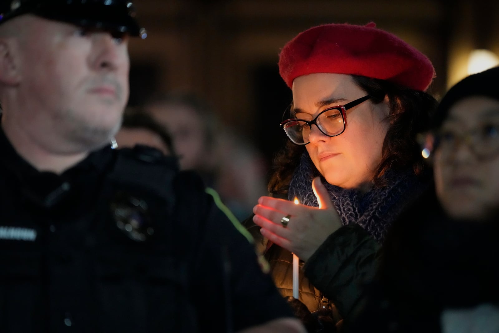 A supporter holds a candle during a candlelight vigil Tuesday, Dec. 17, 2024, outside the Wisconsin Capitol in Madison, Wis., following a shooting at the Abundant Life Christian School on Monday, Dec. 16. (AP Photo/Morry Gash)