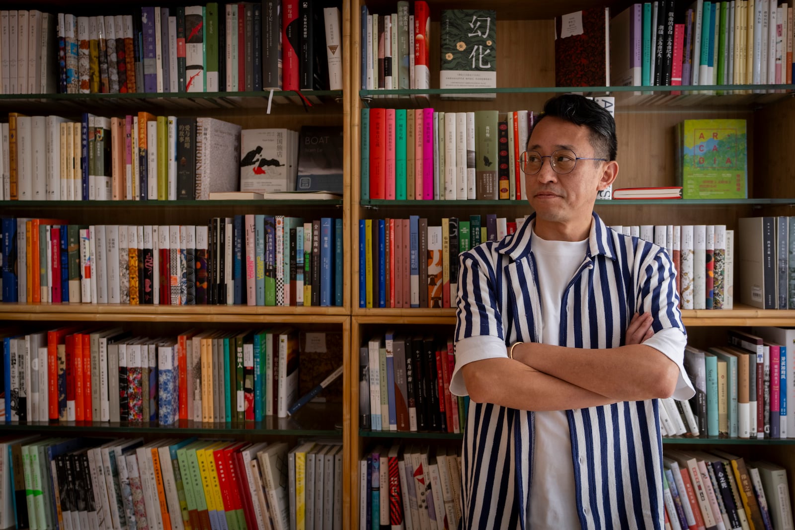 \Yu Miao, owner of JF Books, poses for a photograph in his bookstore in Washington, Thursday, Oct. 3, 2024. (AP Photo/Ben Curtis)