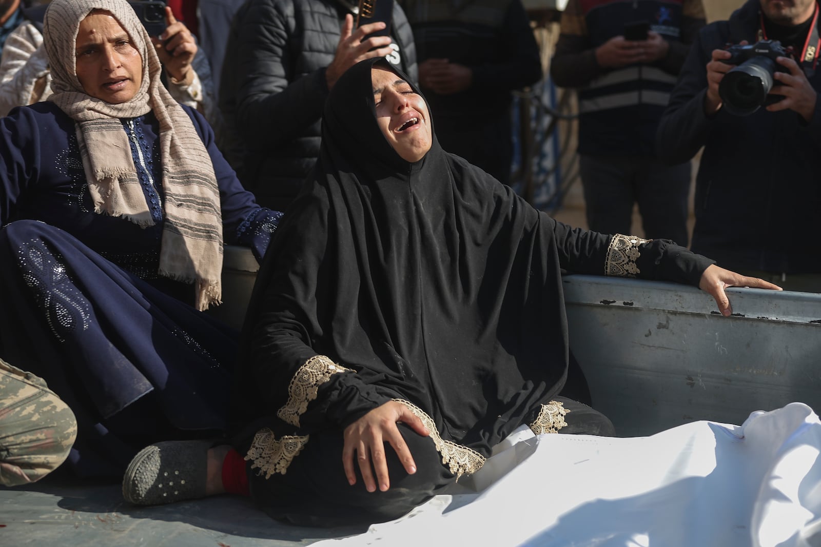 A woman mourns outside the hospital after an airstrike killed several people including children, during an airstrike on a camp for internally displaced people in Maarat Misreen, north of Idlib, Syria, Monday Dec.2, 2024.(AP Photo/Ghaith Alsayed)