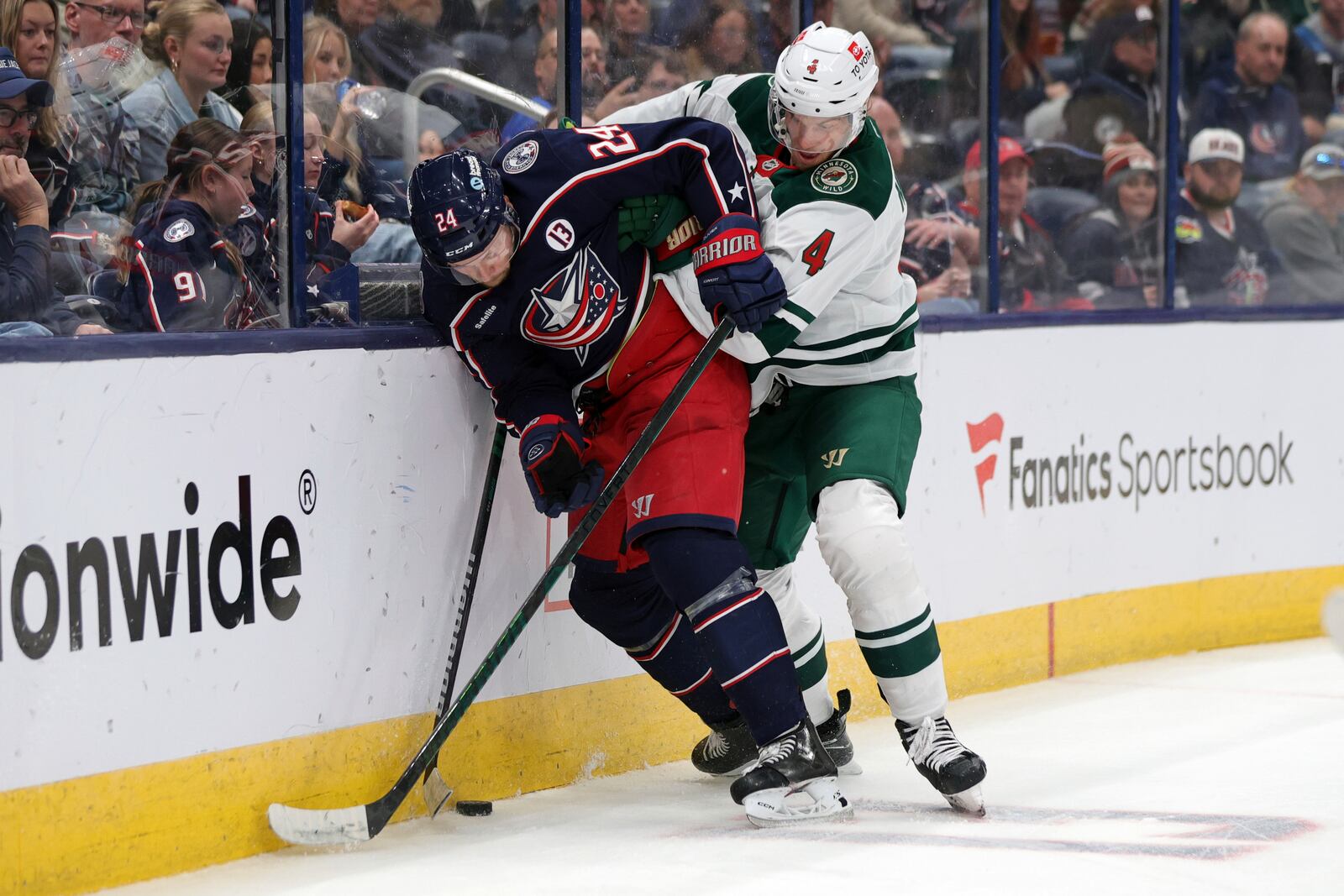 Columbus Blue Jackets forward Mathieu Olivier, left, works for the puck in front of Minnesota Wild defenseman Jon Merrill during the second period of an NHL hockey game in Columbus, Ohio, Saturday, Oct. 19, 2024. (AP Photo/Paul Vernon)