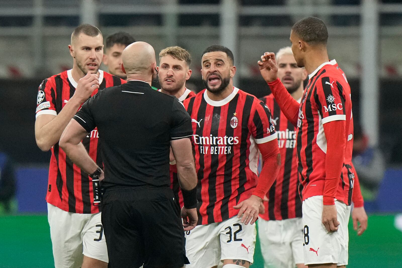 AC Milan's players argue with Referee Szymon Marciniak of Poland after he sent off AC Milan's Theo Hernandez during Champions League, playoff second leg soccer match between AC Milan and Feyenoord, at the San Siro stadium in Milan, Italy, Tuesday, Feb.18, 2025. (AP Photo/Luca Bruno)