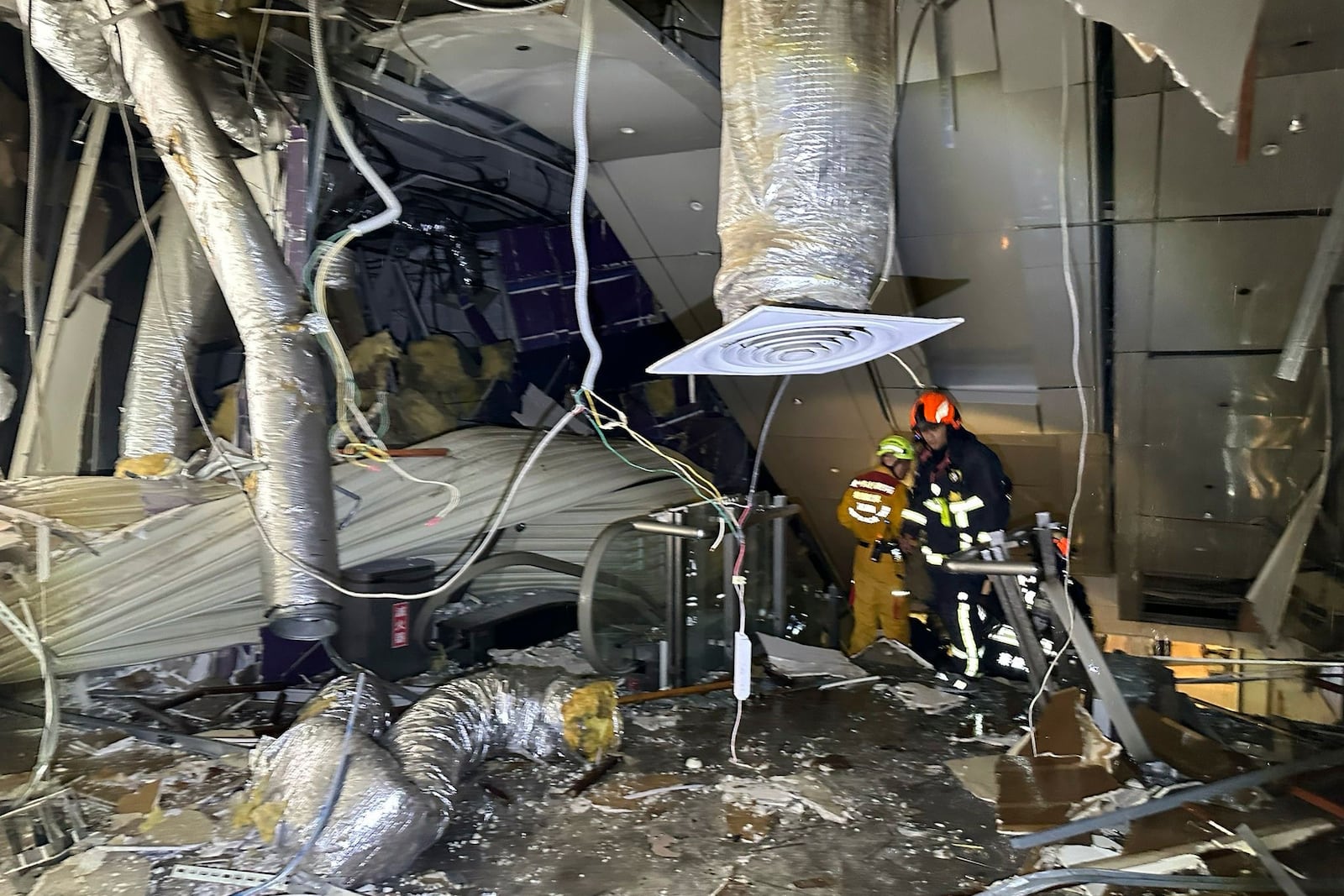 In this photo taken and released by Taichung Fire Bureau, first responders survey the damage in the aftermath of an explosion at the Shin Kong Mitsukoshi department store in Taichung city in Taiwan on Thursday, Feb. 13, 2025. (Taichung Fire Bureau via AP)