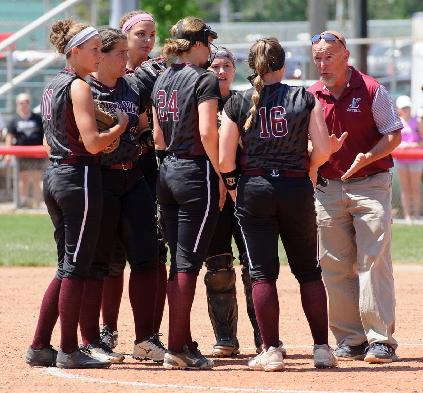 Lebanon assistant coach Scott Urton meets with the Warrior infielders during the seventh inning of Saturday’s Division I state final against Elyria at Firestone Stadium in Akron. CONTRIBUTED PHOTO BY BRYANT BILLING