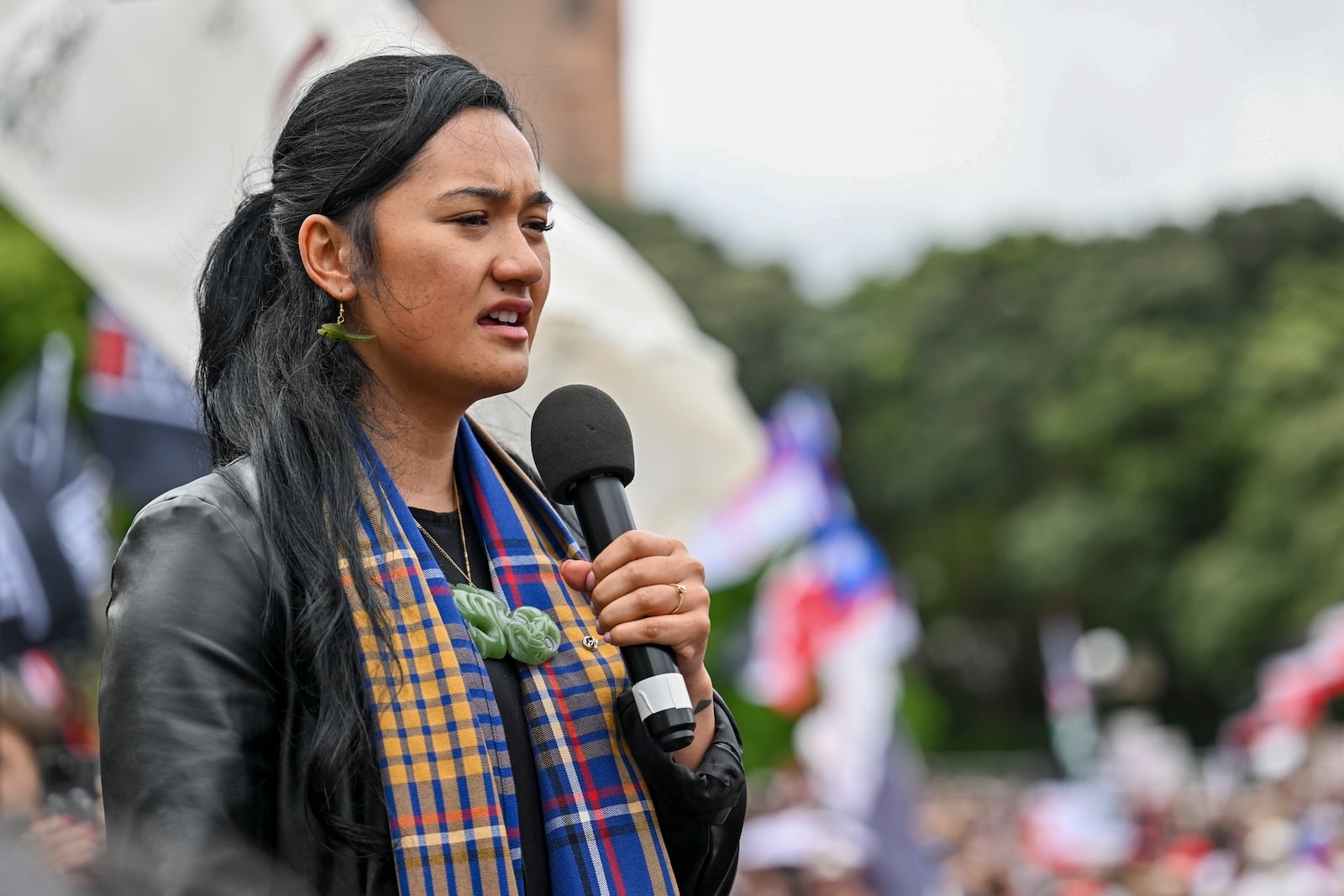 Hana-Rāwhiti Maipi-Clarke speaks to the thousands of people gathered outside New Zealand's parliament to protest a proposed law that would redefine the country's founding agreement between Indigenous Māori and the British Crown, in Wellington Tuesday, Nov. 19, 2024. (AP Photo/Mark Tantrum)