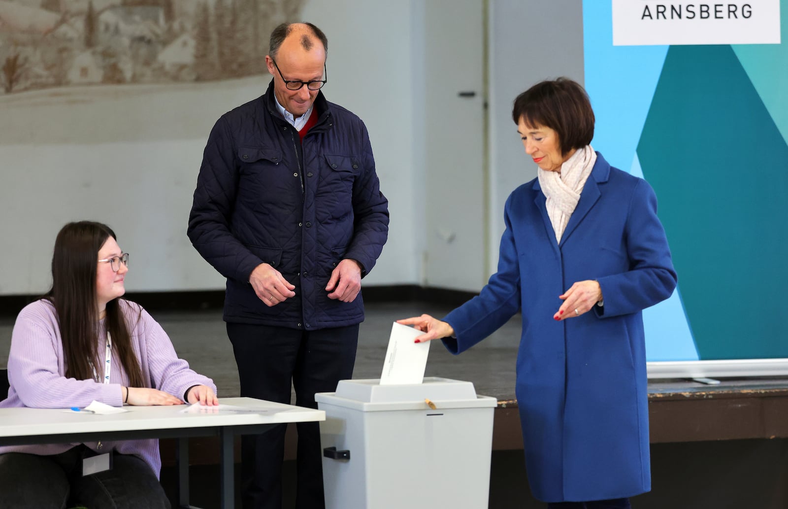 Friedrich Merz, center, leader of the Christian Democratic Union (CDU), and and his wife Charlotte Merz, right, cast their vote at a polling station in Arnsberg-Niedereimer, Germany, Sunday, Feb. 23, 2025, during the national election. (Rolf Vennenbernd/dpa via AP)