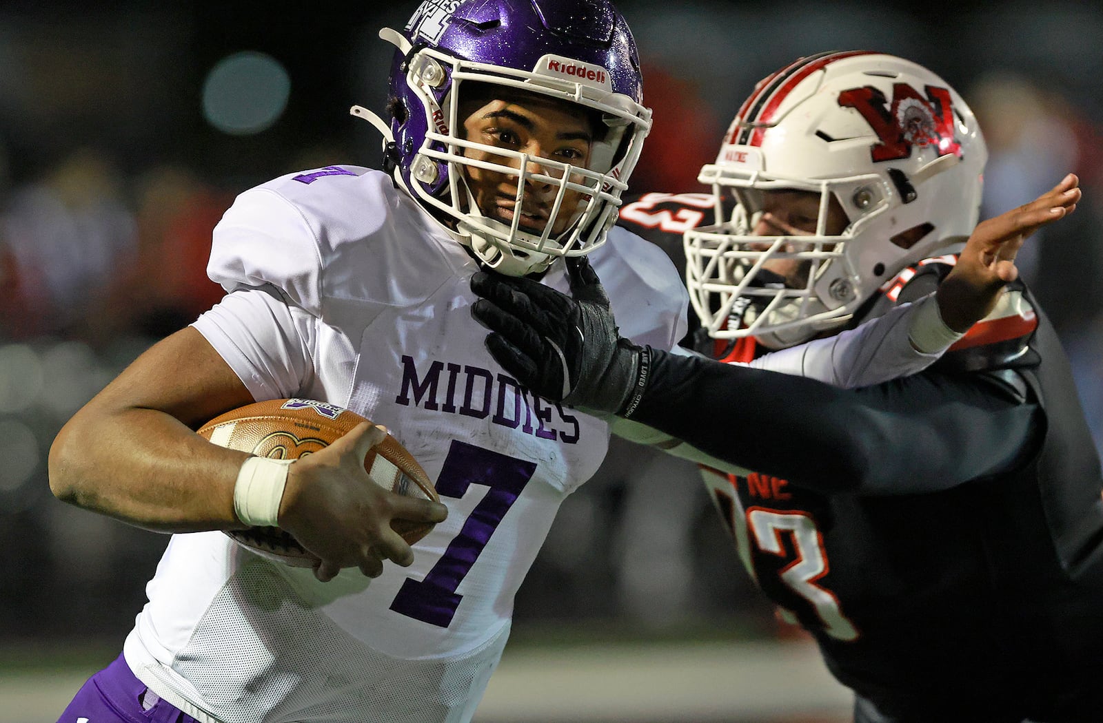 Middletown quarterback Jeremiah Landers tries to avoid being tackled by Wayne's Dorien Alcorn during Friday's playoff game. BILL LACKEY/STAFF