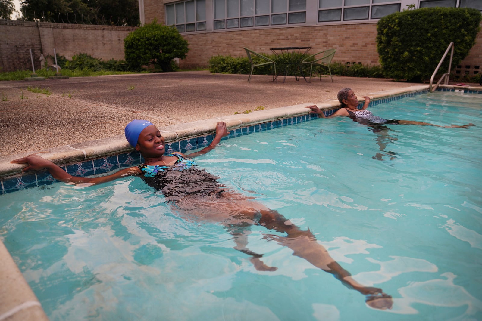 Sister Seyram Mary Adzokpa and Sister Clara Mae Jackson, of the Sisters of the Holy Family, swim in the pool at the motherhouse in New Orleans, Tuesday, June 25, 2024. (AP Photo/Jessie Wardarski)